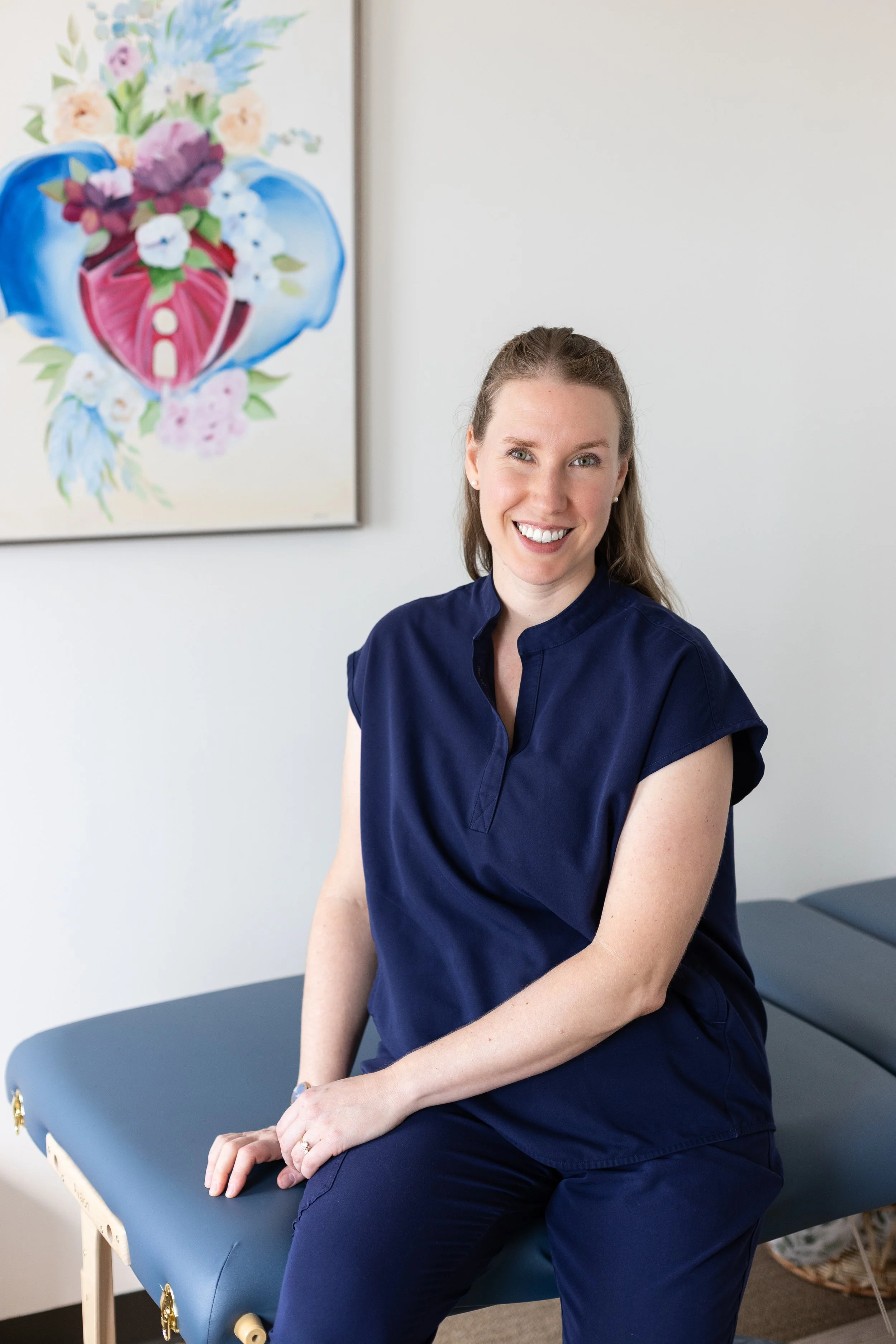 Dr. Savannah in her welcoming office in Brentwood, MO with pelvis painting in background