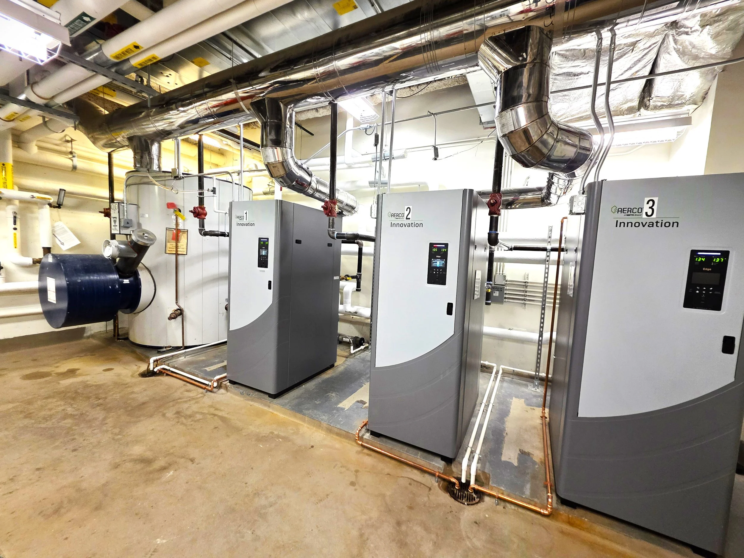 Industrial boiler system with metal pipes and control units in a utility room.