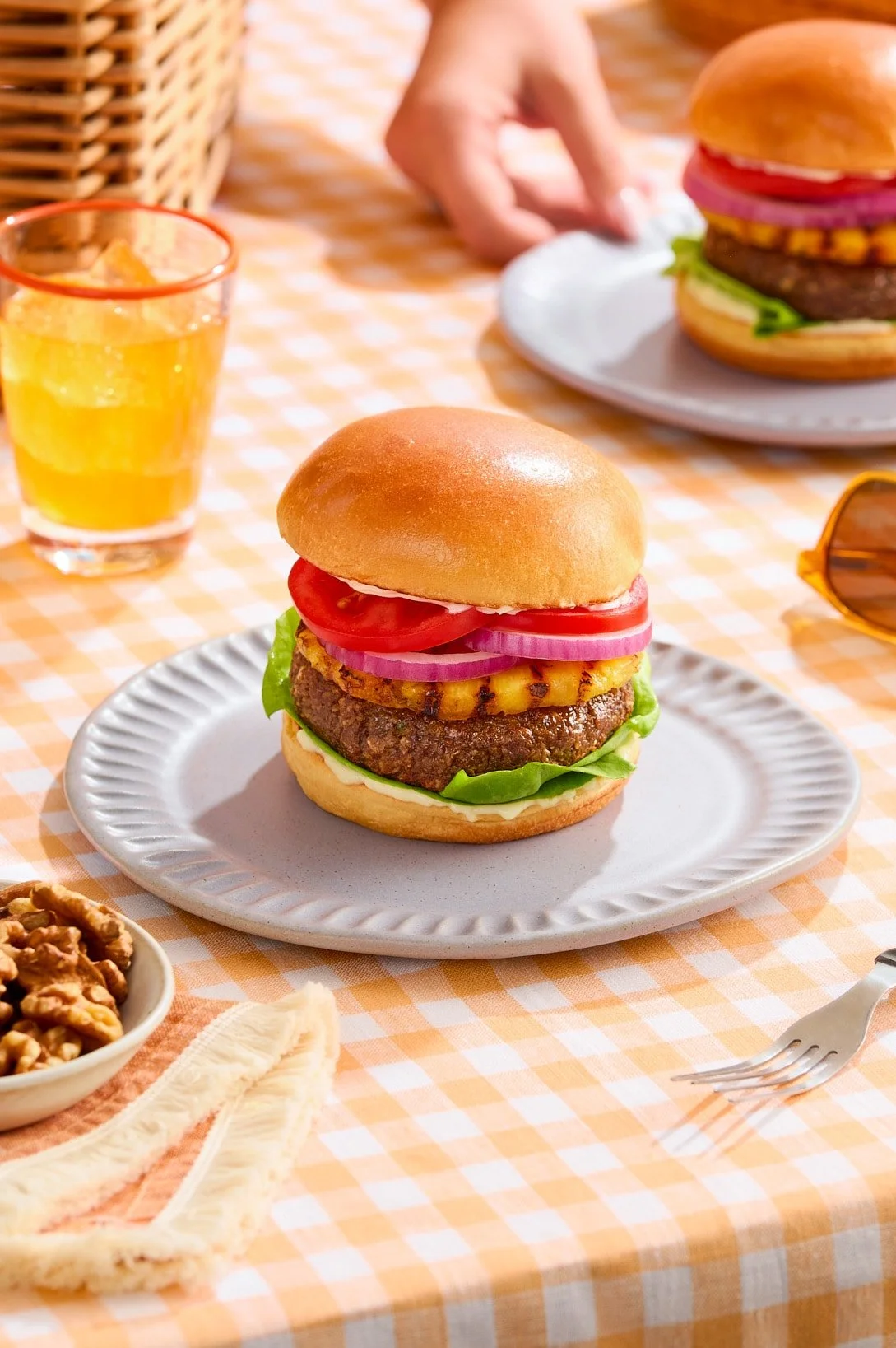 A walnut veggie burger in a summery picnic setting.