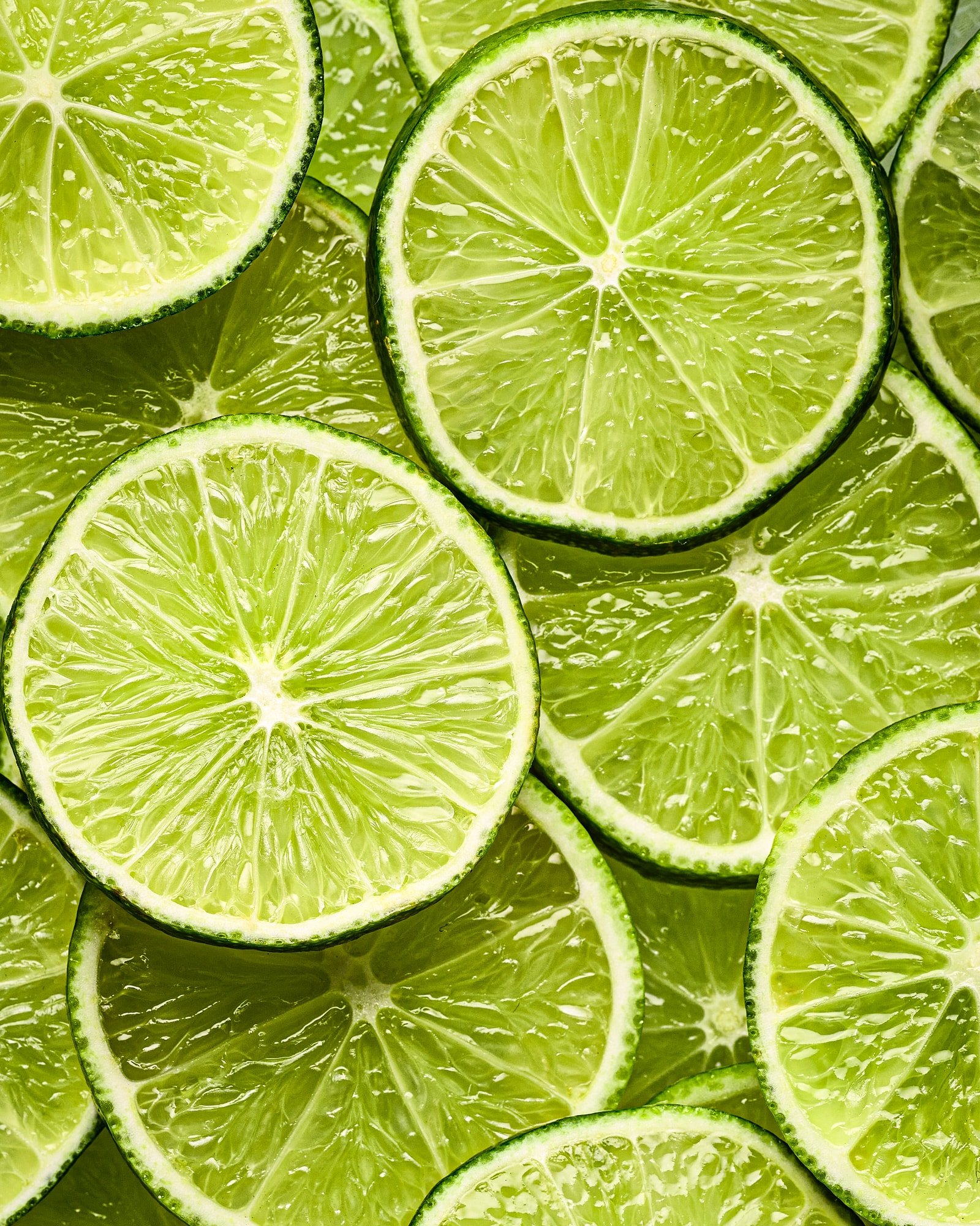 Close-up of overlapping fresh lime slices with visible pulp and seeds