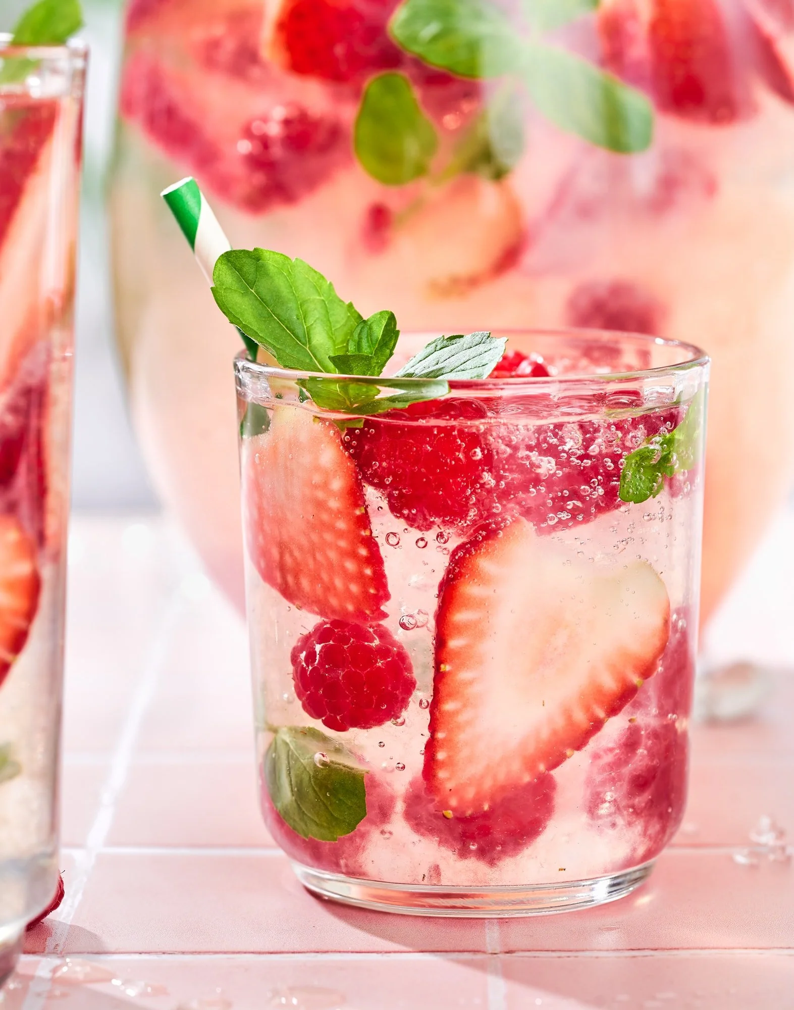 Sparkling berry-infused water with strawberries, raspberries, mint, and ice in a glass