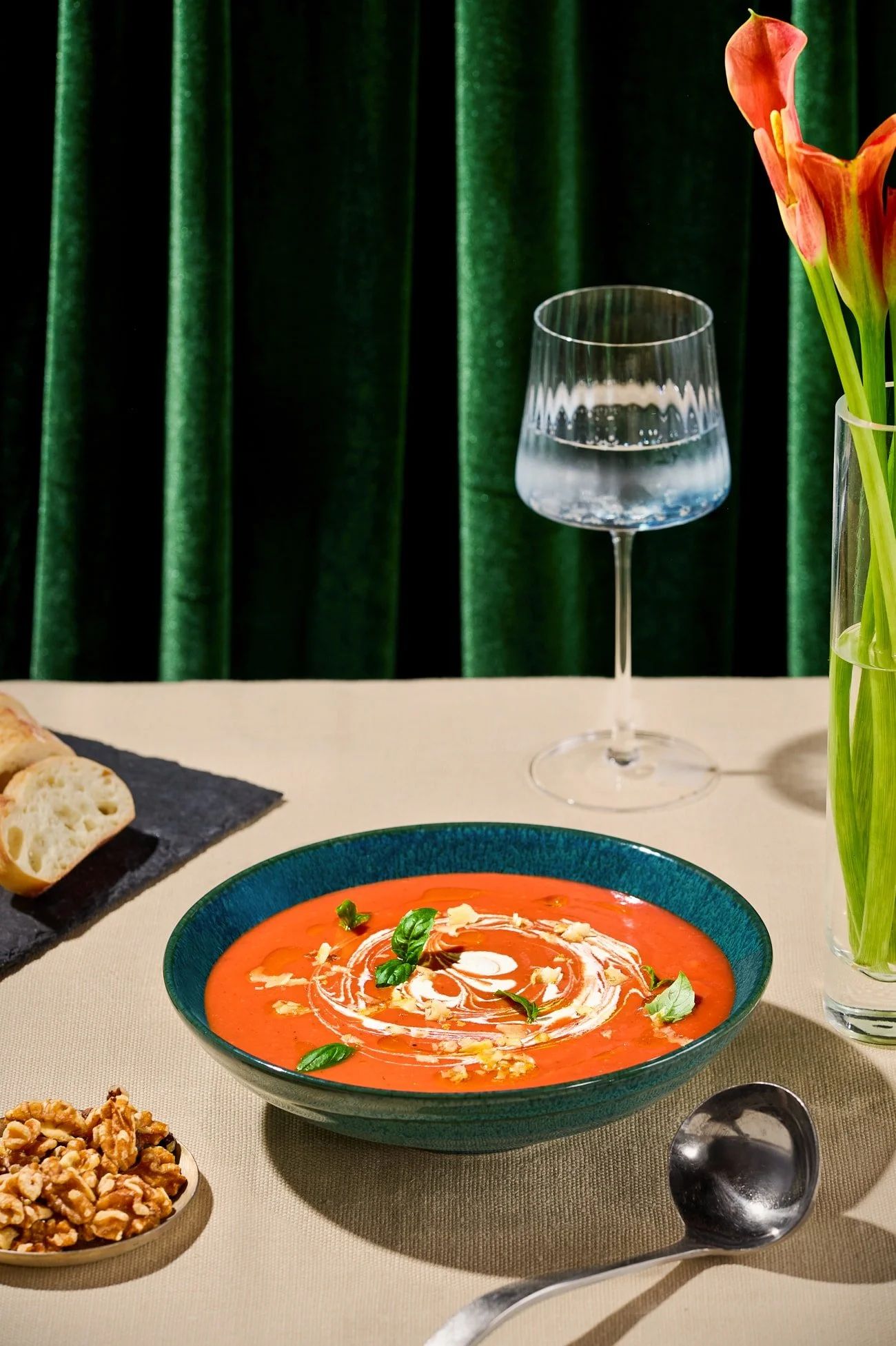 Walnut Tomato Soup with a creamy swirl on a green velvet background.