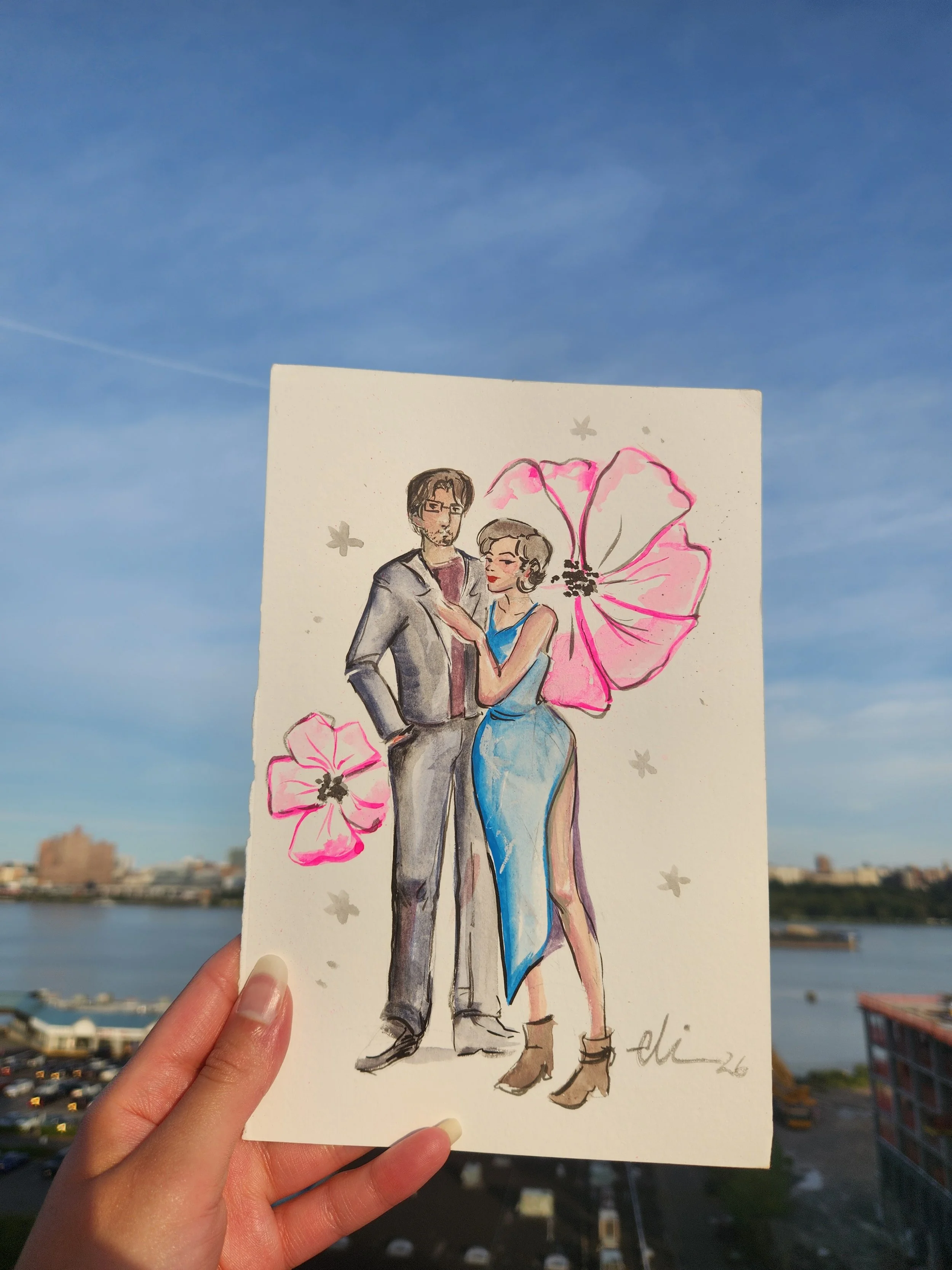 A hand holding a watercolor illustration of a man and woman standing together, with large pink and purple flowers and gray stars in the background, set against a bright blue sky with some clouds.