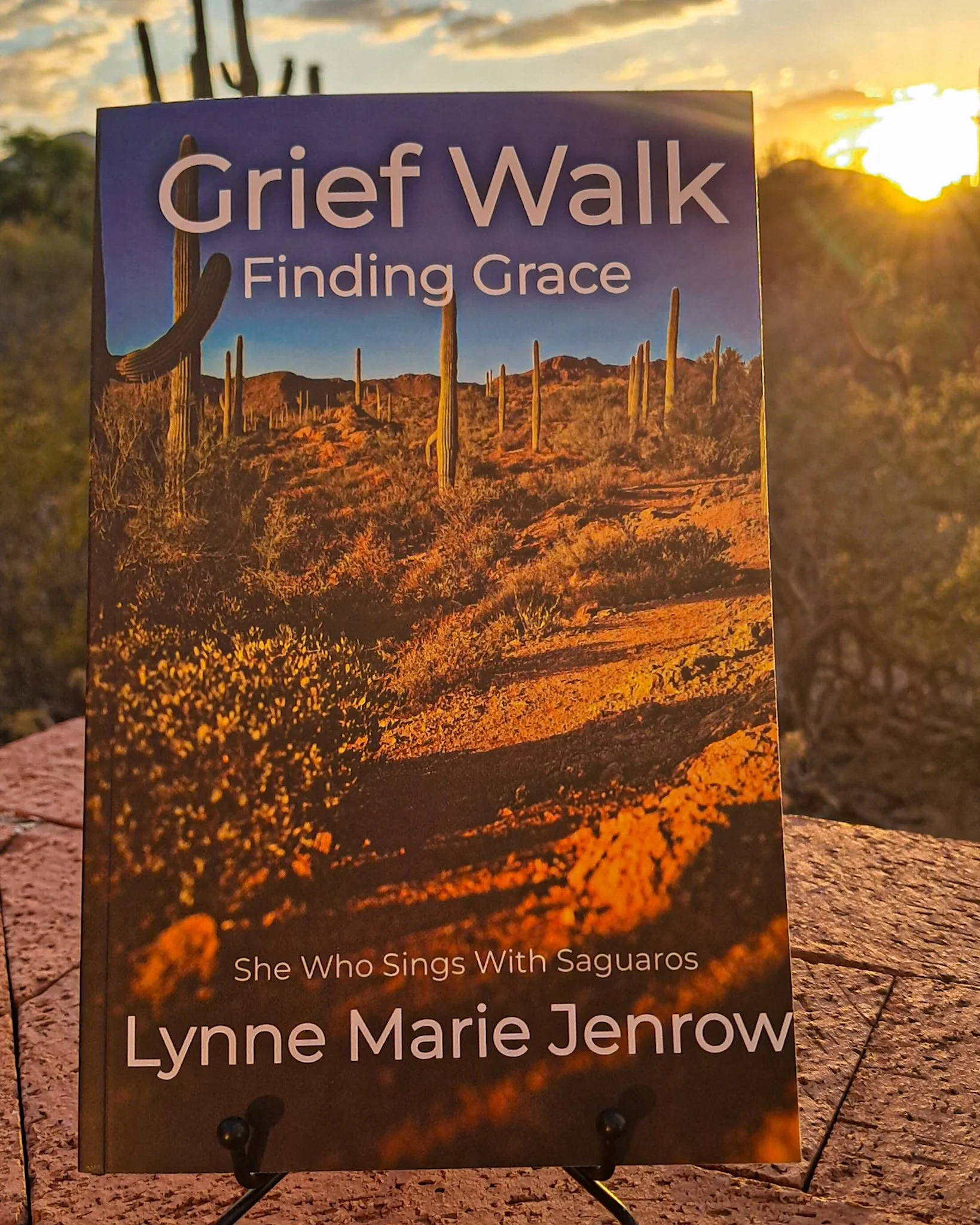 Book cover titled "Grief Walk: Finding Grace" by Lynne Marie Jenrow, featuring a desert landscape with cacti at sunset.