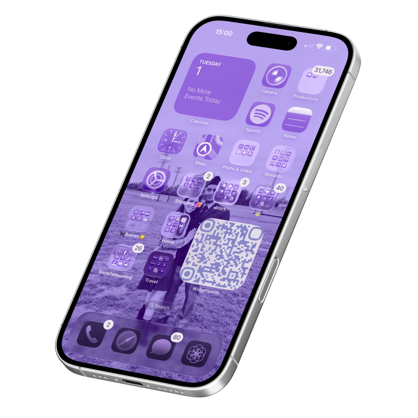 A smartphone with a purple-themed home screen displaying various app icons, folders, and a QR code, with a background photo of a couple standing outdoors.