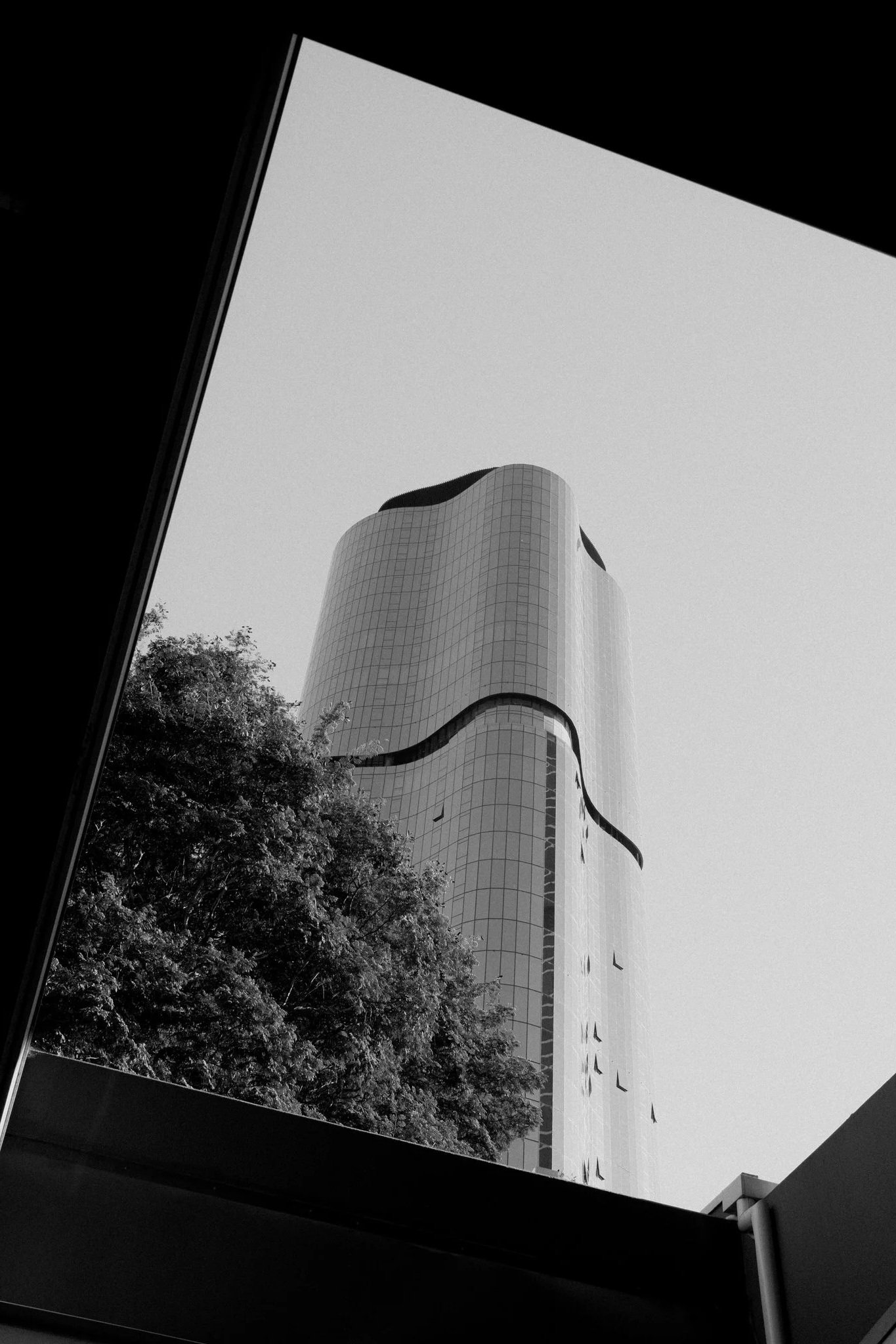 Architecture+-+Modern+curved+tower+against+minimalist+sky+and+foliage+-+TVS.jpg