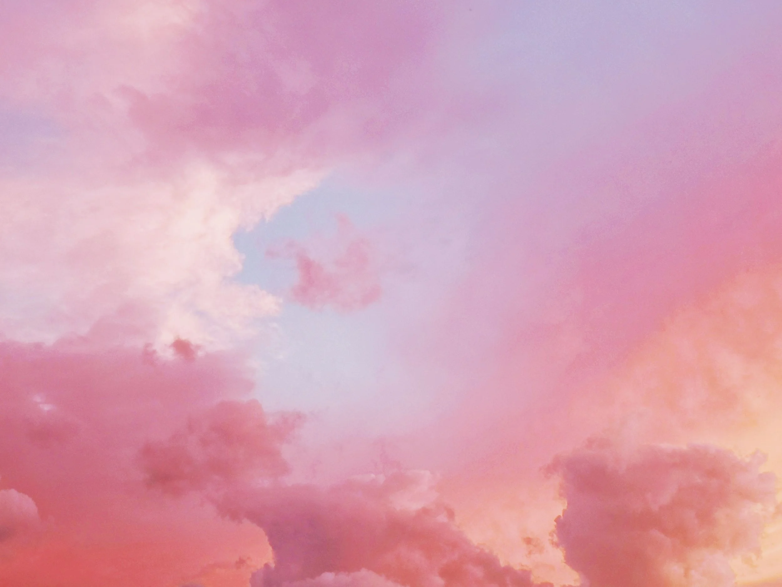 A sky with pink and purple clouds during sunset.