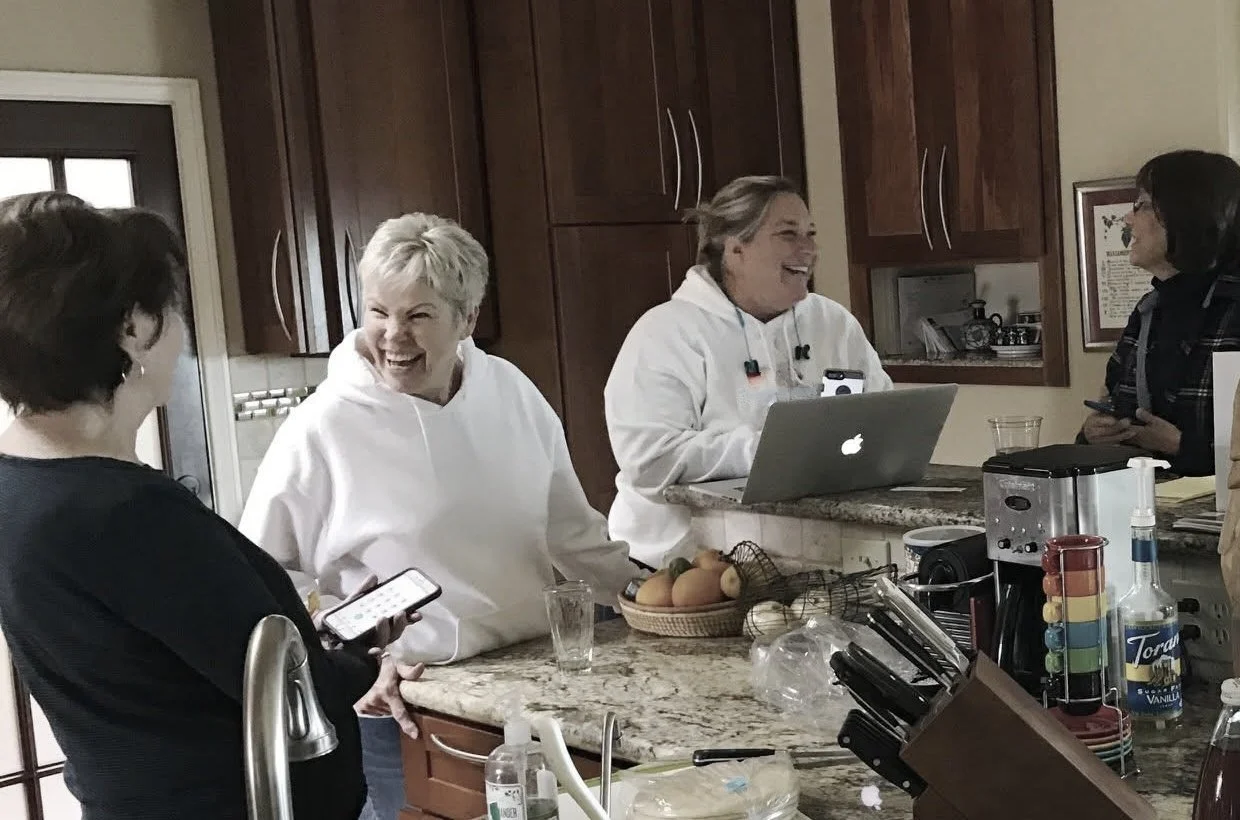 People gathered around a kitchen counter, working together