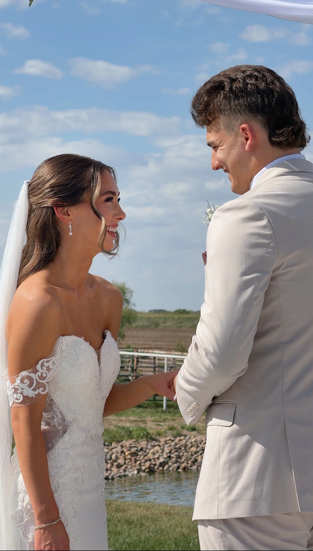 Bride and Groom in field at Seven Willows holding each other.
