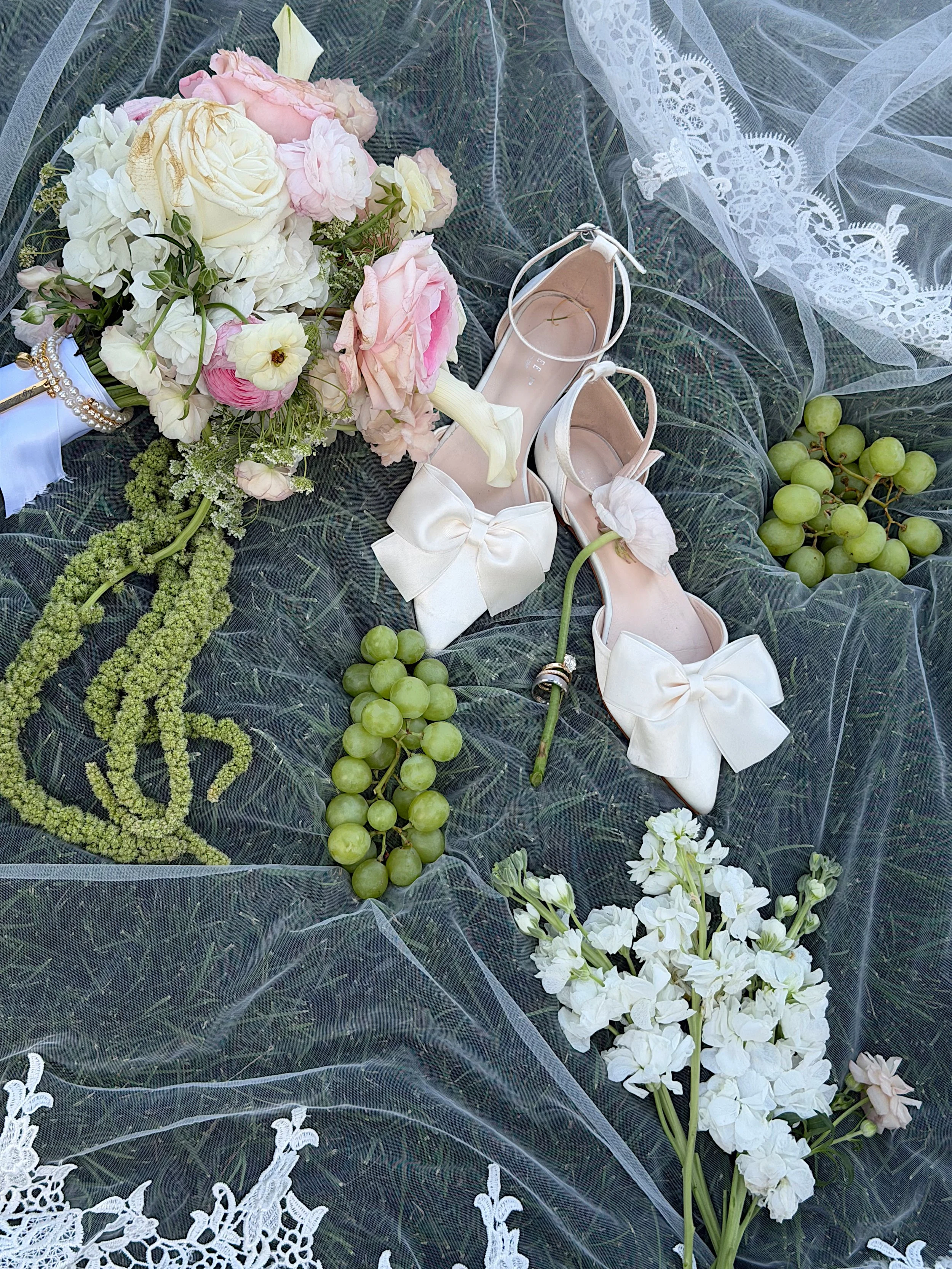 Veil on top of grass at The Empire Room with heels and flowers.