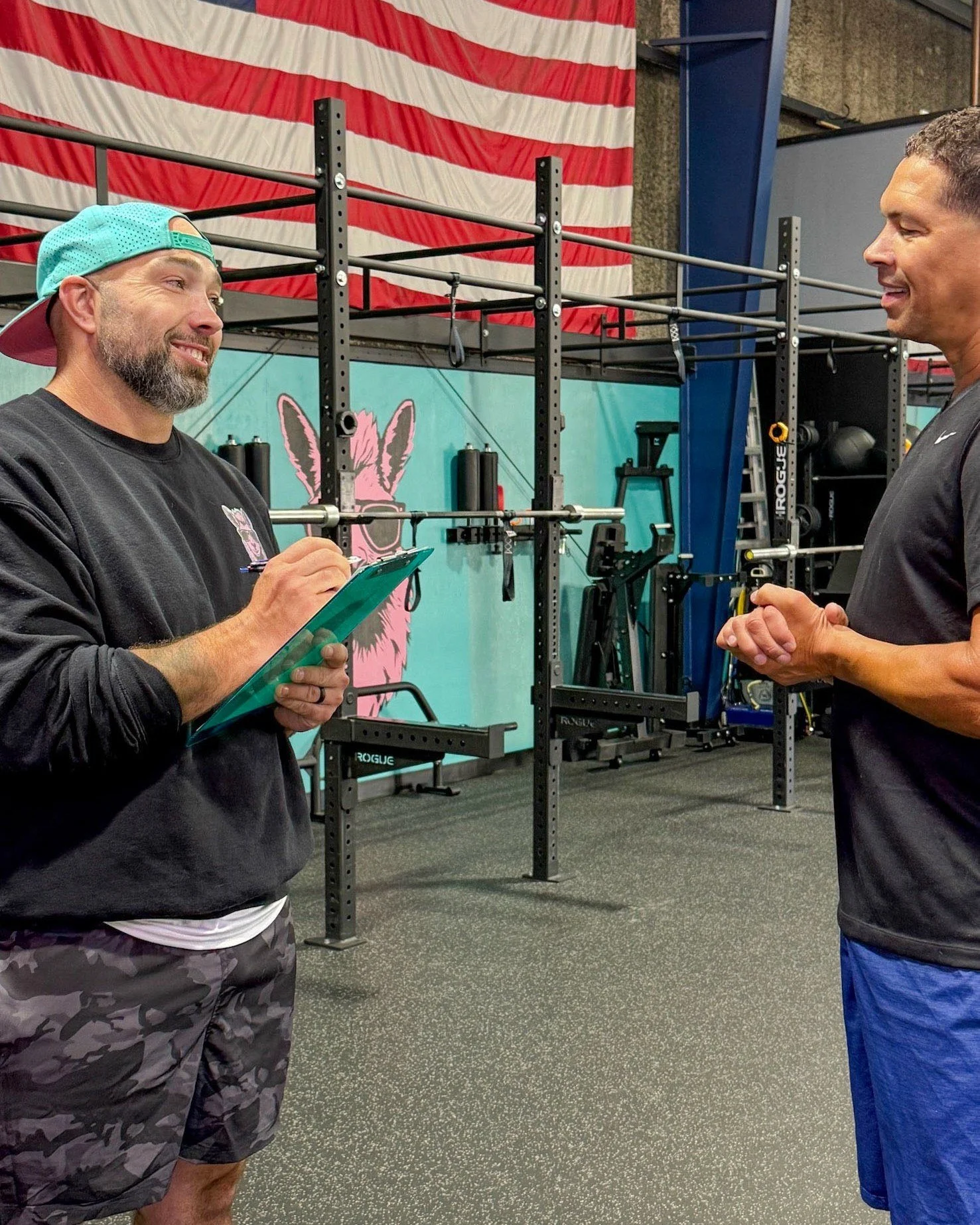 Pink Llama Fitness coach reviewing a training plan with a Personal Training member