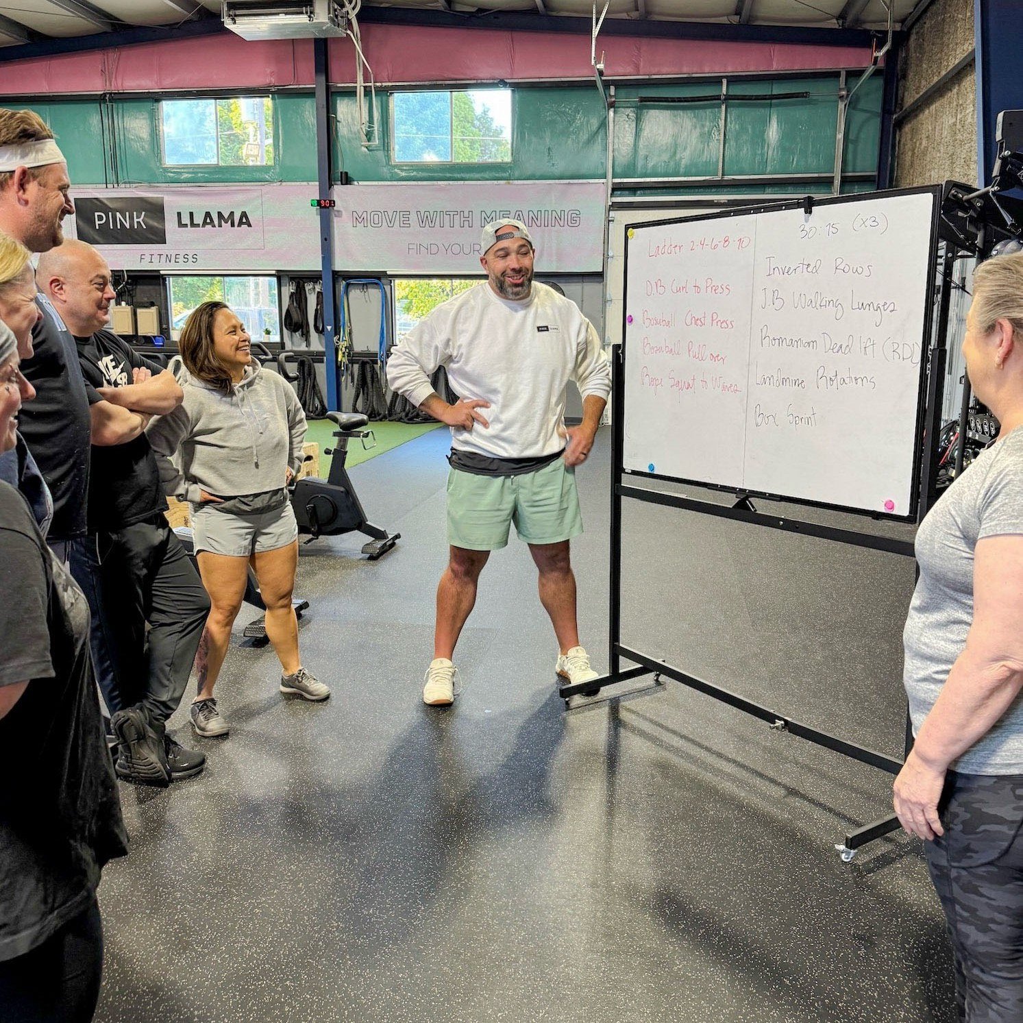 Pink Llama Fitness coach explaining the workout to Group Training members