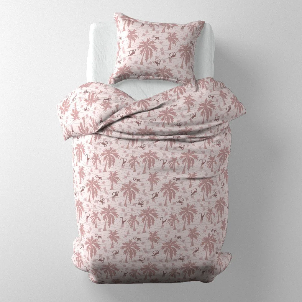 Bedding set mockup on a single bed featuring blush-pink linen printed with palm trees and illustrated swinging monkeys.