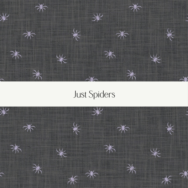 A dark fabric with small purple spider illustrations scattered across it, with a white band in the center containing the text 'Just Spiders'