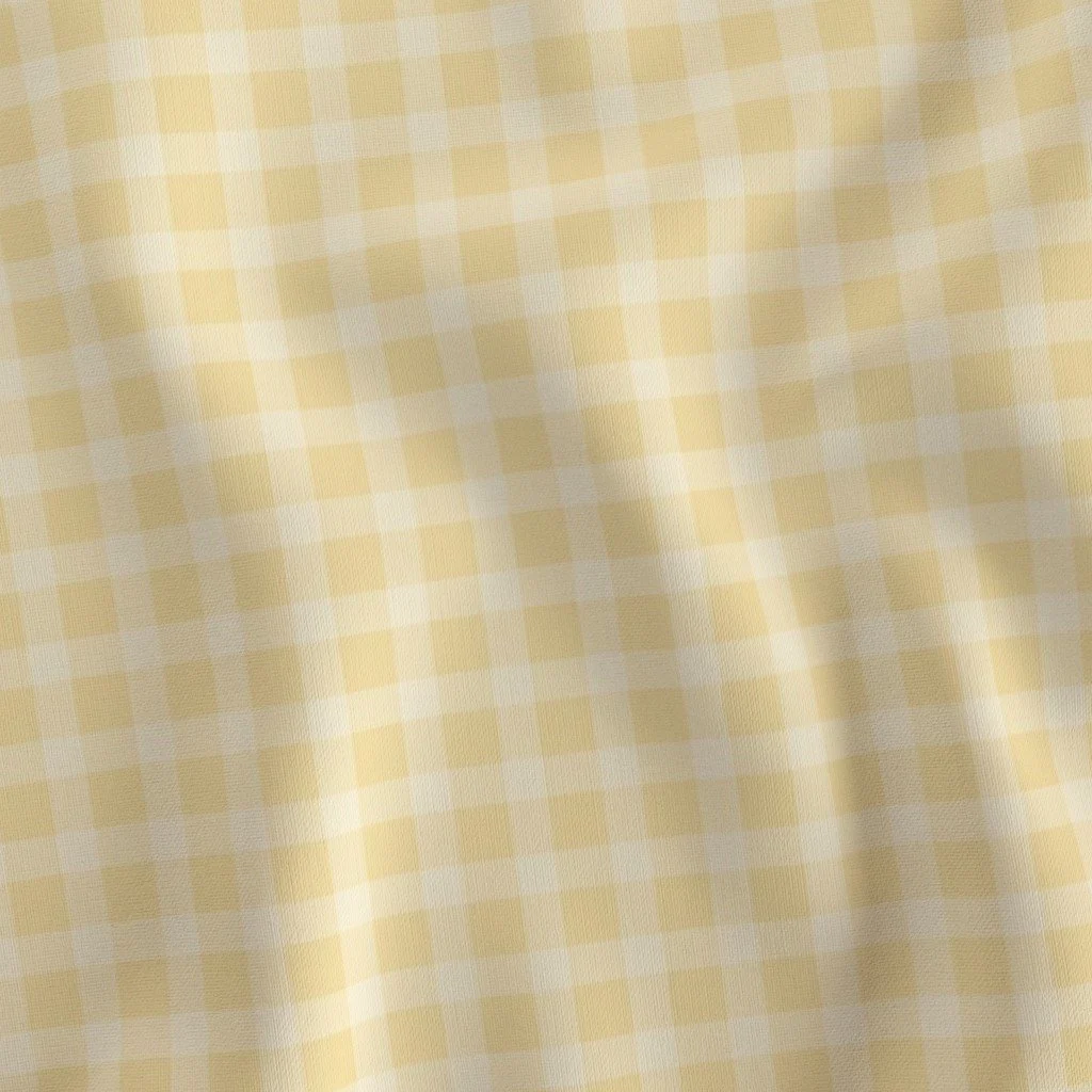 Draped fabric showcasing a classic pastel butter-yellow and white gingham check pattern.