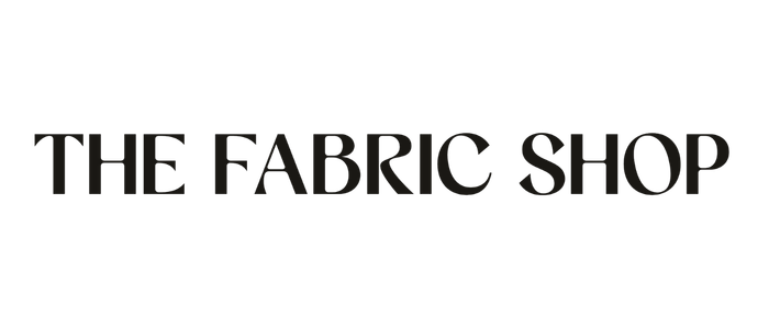 Logo for The Fabric Shop in black and gray text.