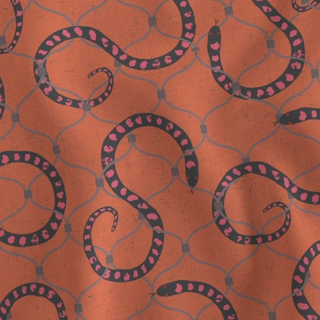 Terracotta-toned fabric printed with black, pink-spotted snakes slithering and weaving through a chain link fence