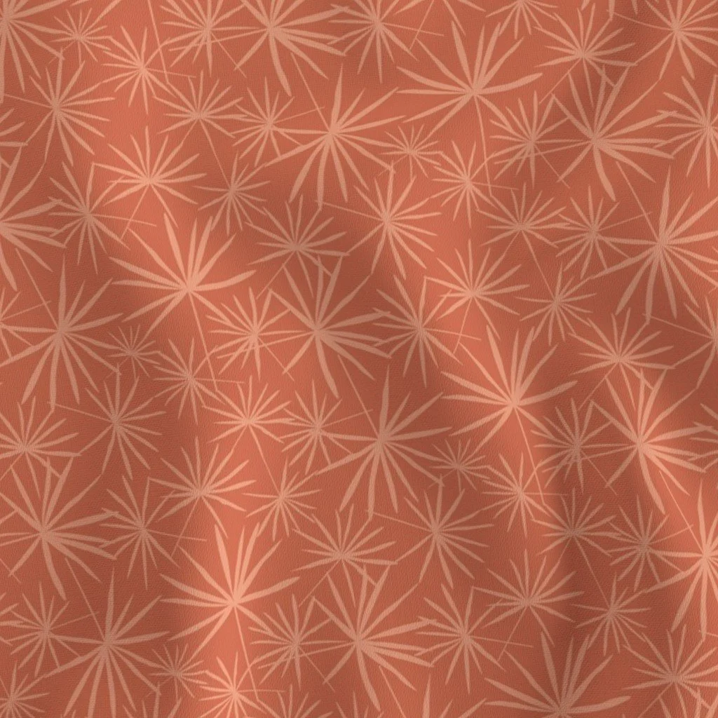 Rust-orange woven fabric featuring a dense, overlapping pattern of spiky, fan-palm-style botanical starbursts in a soft peach tint.