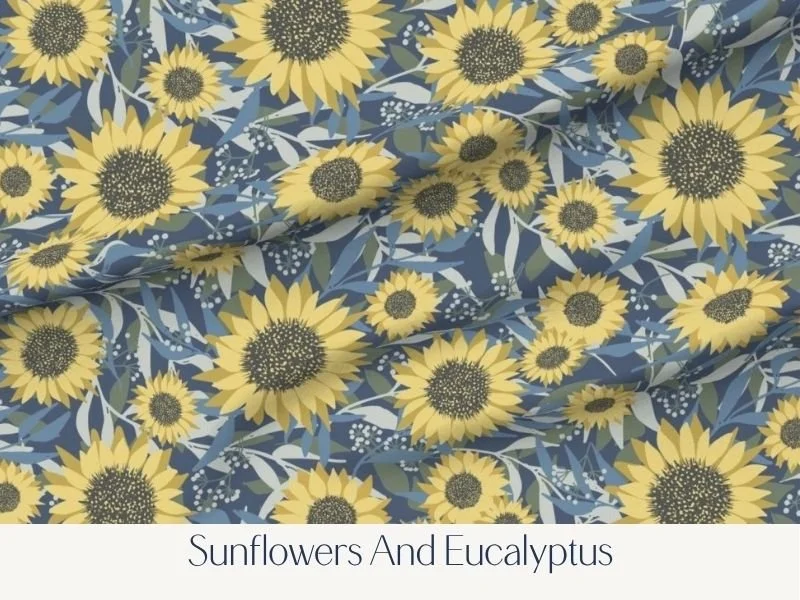 Fabric pattern of yellow sunflowers and greyish-green eucalyptus leaves on a dark blue background.