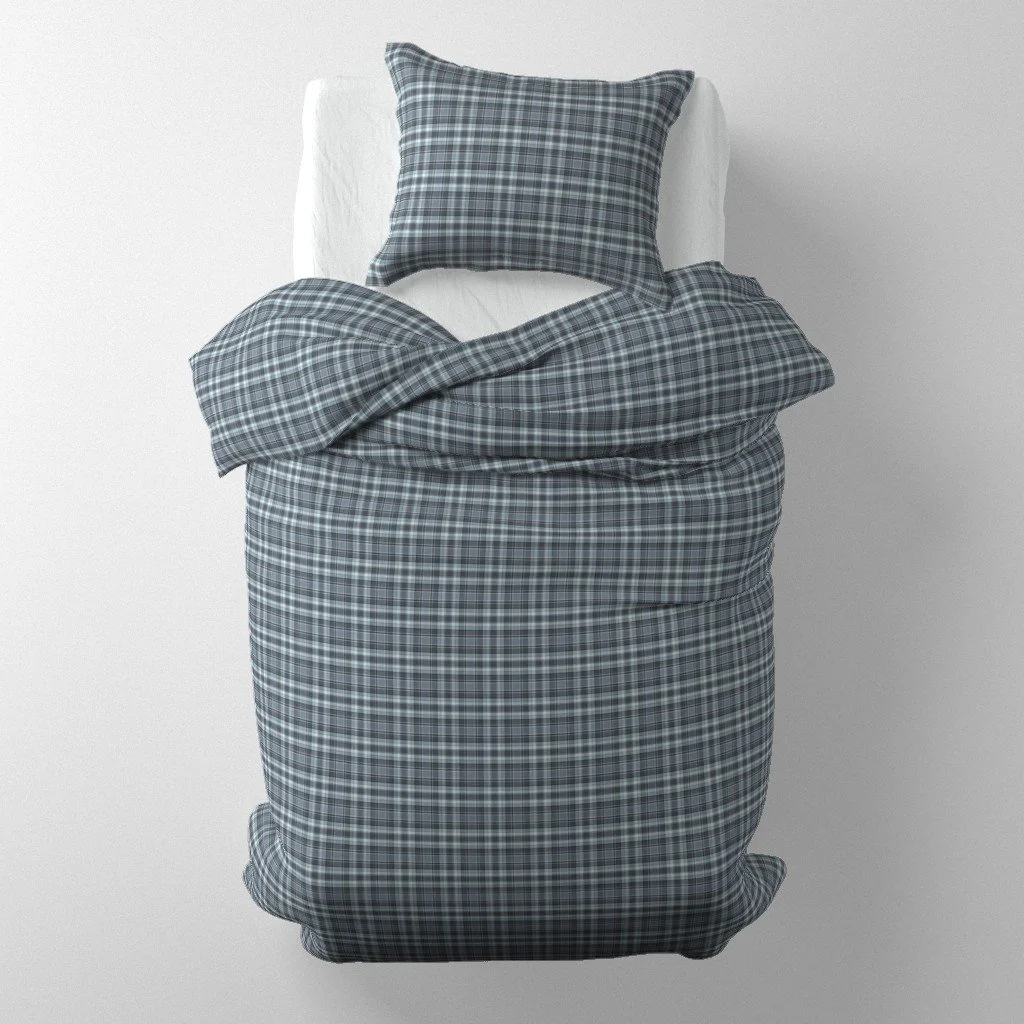 Bedding set mockup on a single bed featuring a duvet and pillow in a slate-blue and white woven plaid check.