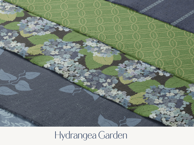 Close-up of various fabric pieces with different floral and geometric patterns, labeled as Hydrangea Garden.