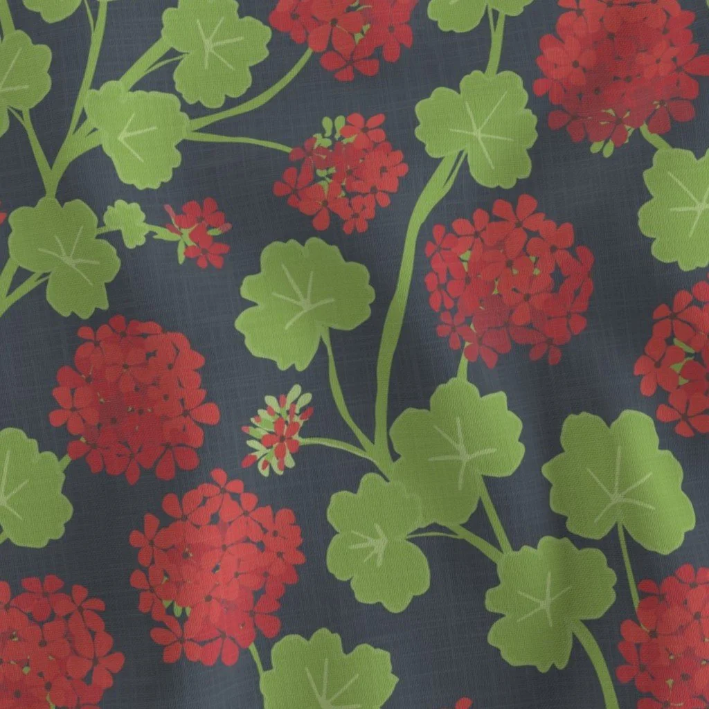 Dark charcoal textured fabric featuring a botanical print of bright red geranium blooms and scalloped green leaves on slender stems.