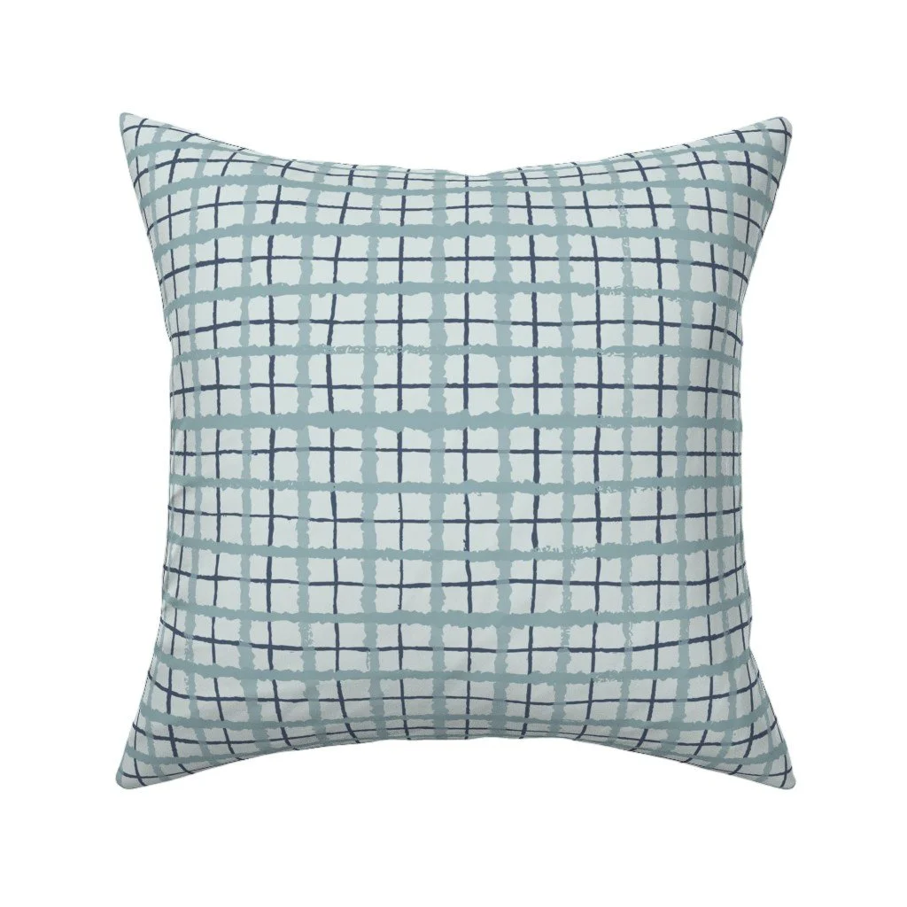 Off-white throw pillow patterned with an overlapping, hand-drawn windowpane grid in dusty slate blue and dark navy.