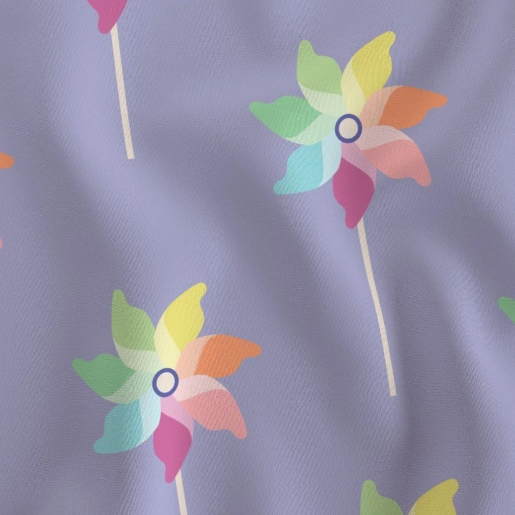 Dusty periwinkle fabric patterned with illustrated pastel rainbow pinwheels on slender white sticks.