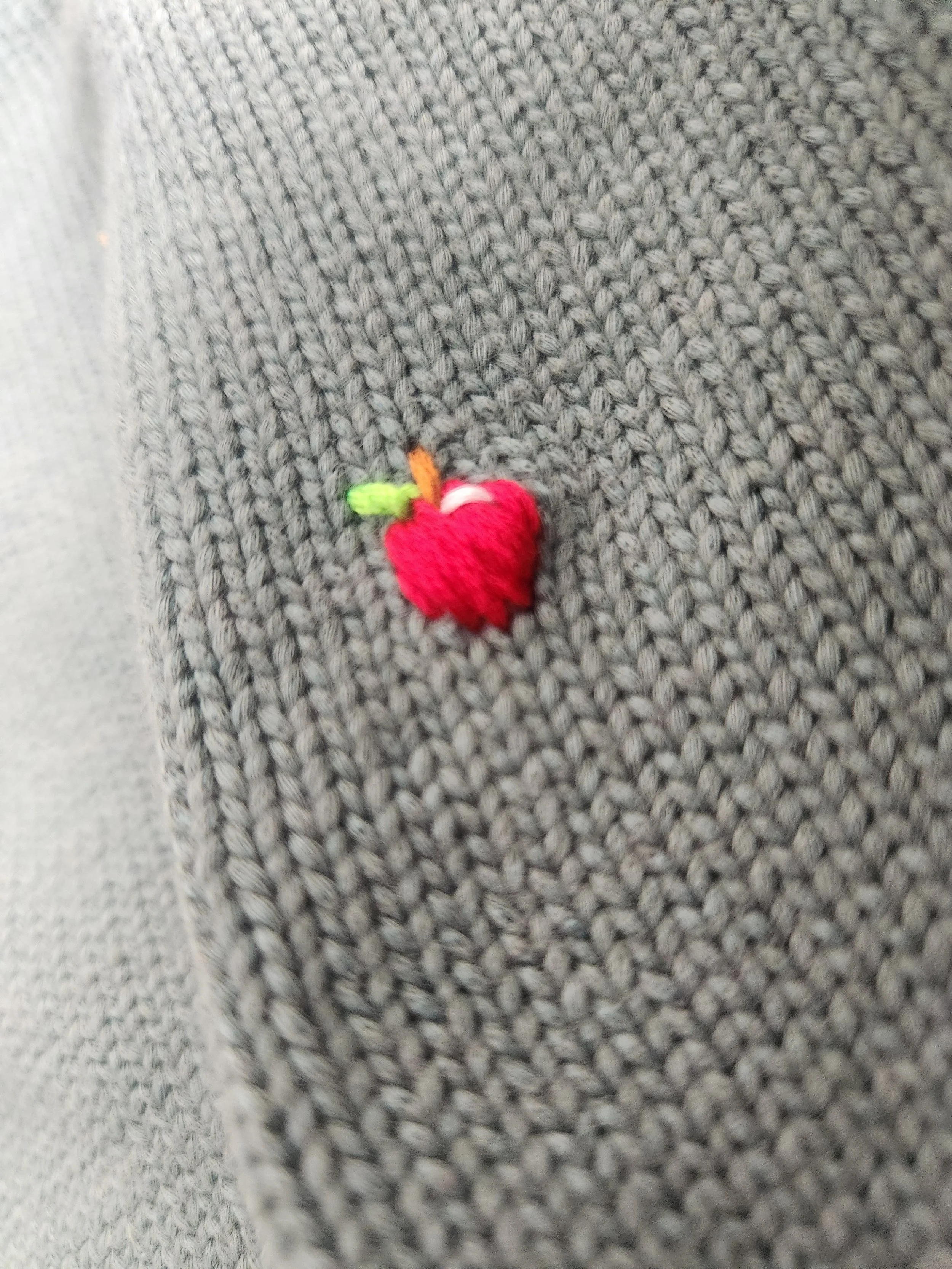 Of Character embroidered Apple detail on upcycled sweater.jpg
