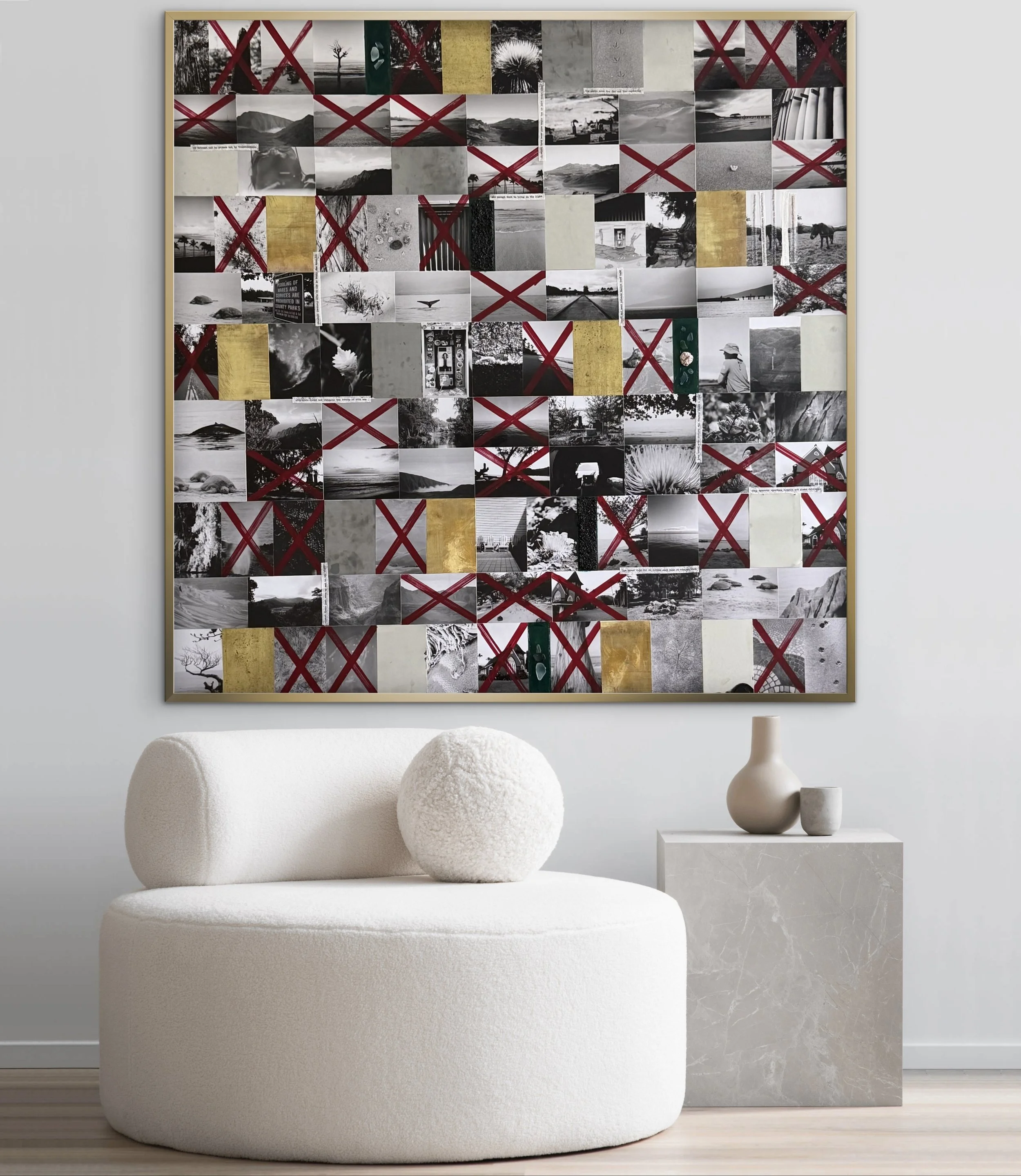 Modern white upholstered armchair with rounded edges, two textured spheres placed on it, set against a white wall. Behind the chair, a large framed collage of black-and-white photographs with some gold accents and red X marks is displayed. To the rig