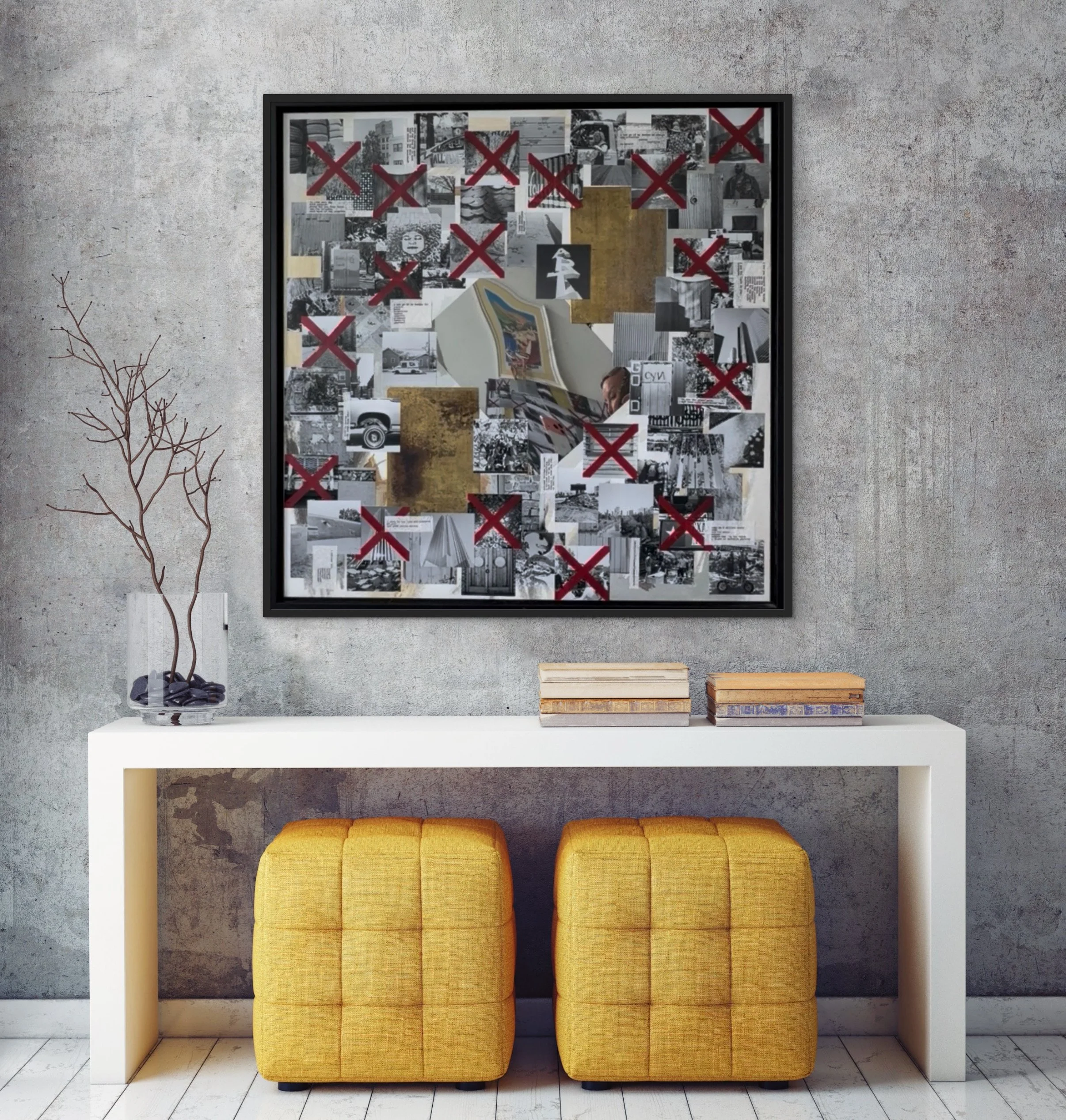 Interior of a modern room with a textured concrete wall. A white table holds a small leafless tree in a glass jar and three books with colorful covers. Two yellow cushioned stools are placed beneath the table. Behind is a framed collage of black-and-