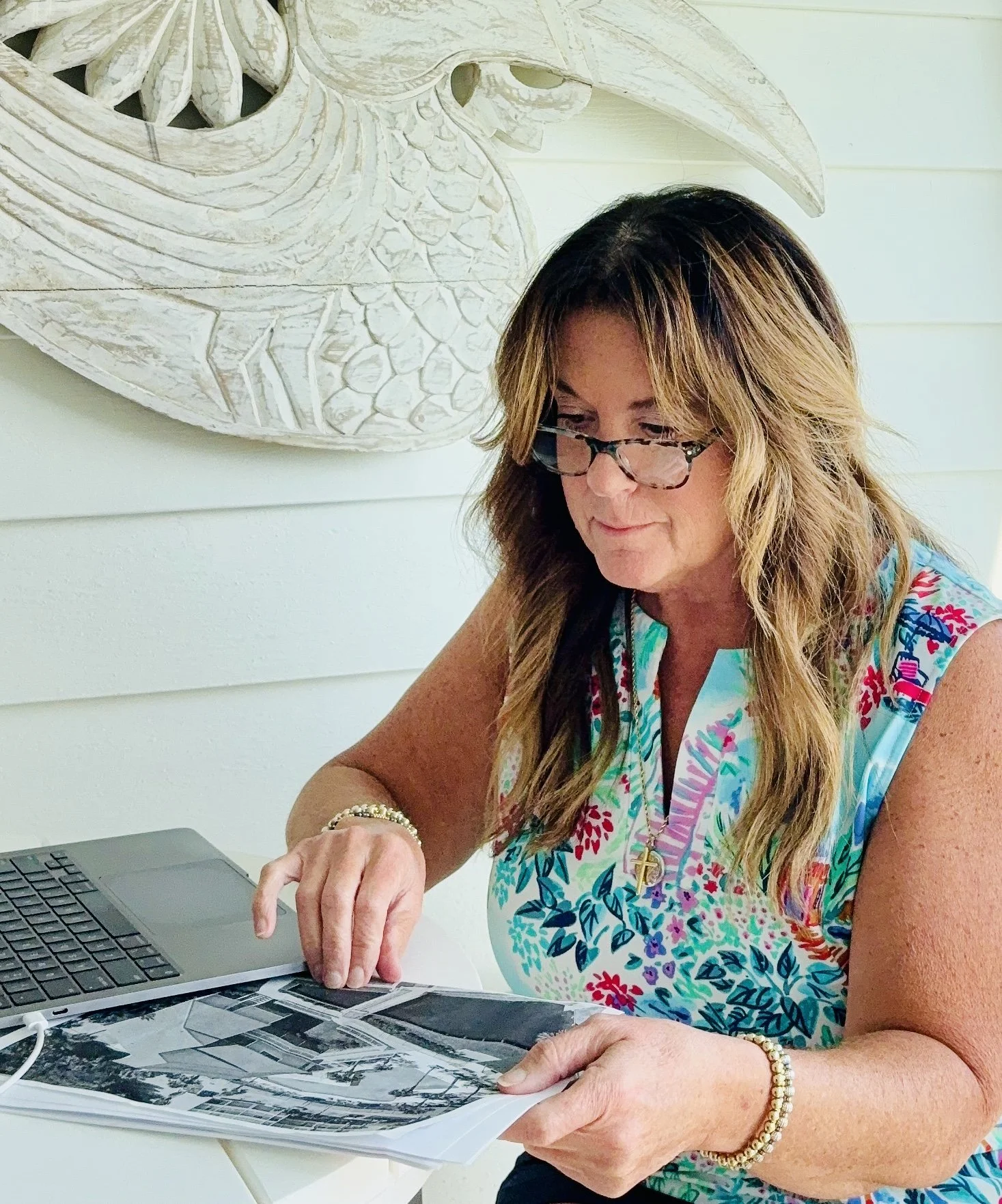 The Renovation Concierge reviewing home design photographs at her workspace.