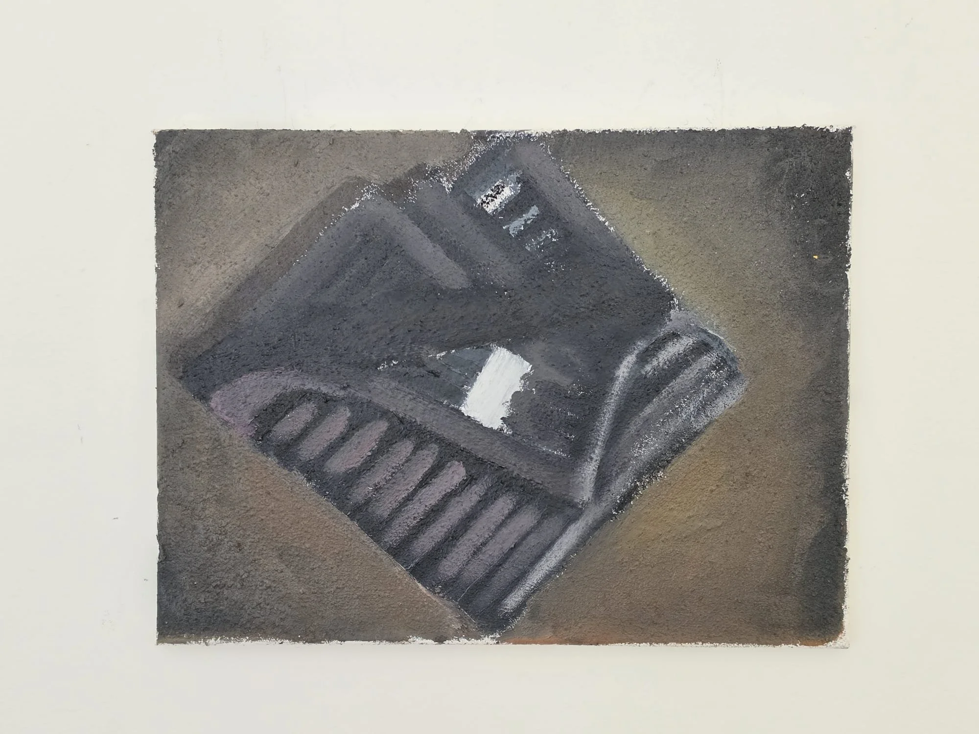 A framed painting of a black and grey dishcloth on a dark background.