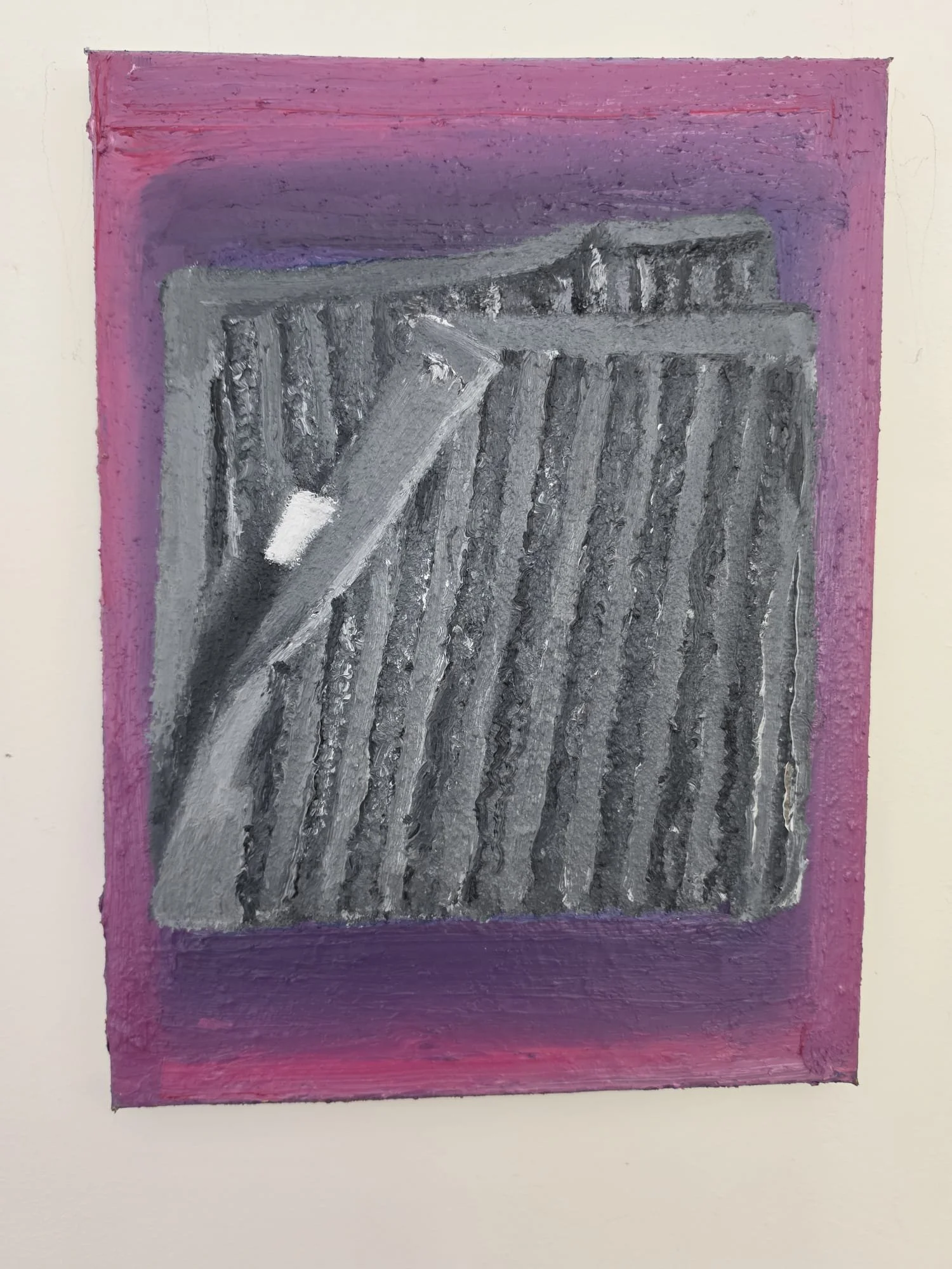A framed painting of a black and grey dishcloth on a pink background.