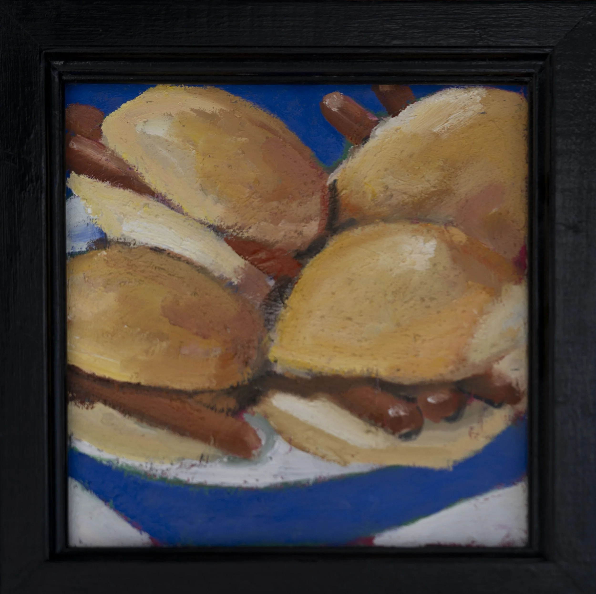 A framed painting of sausages in buns.