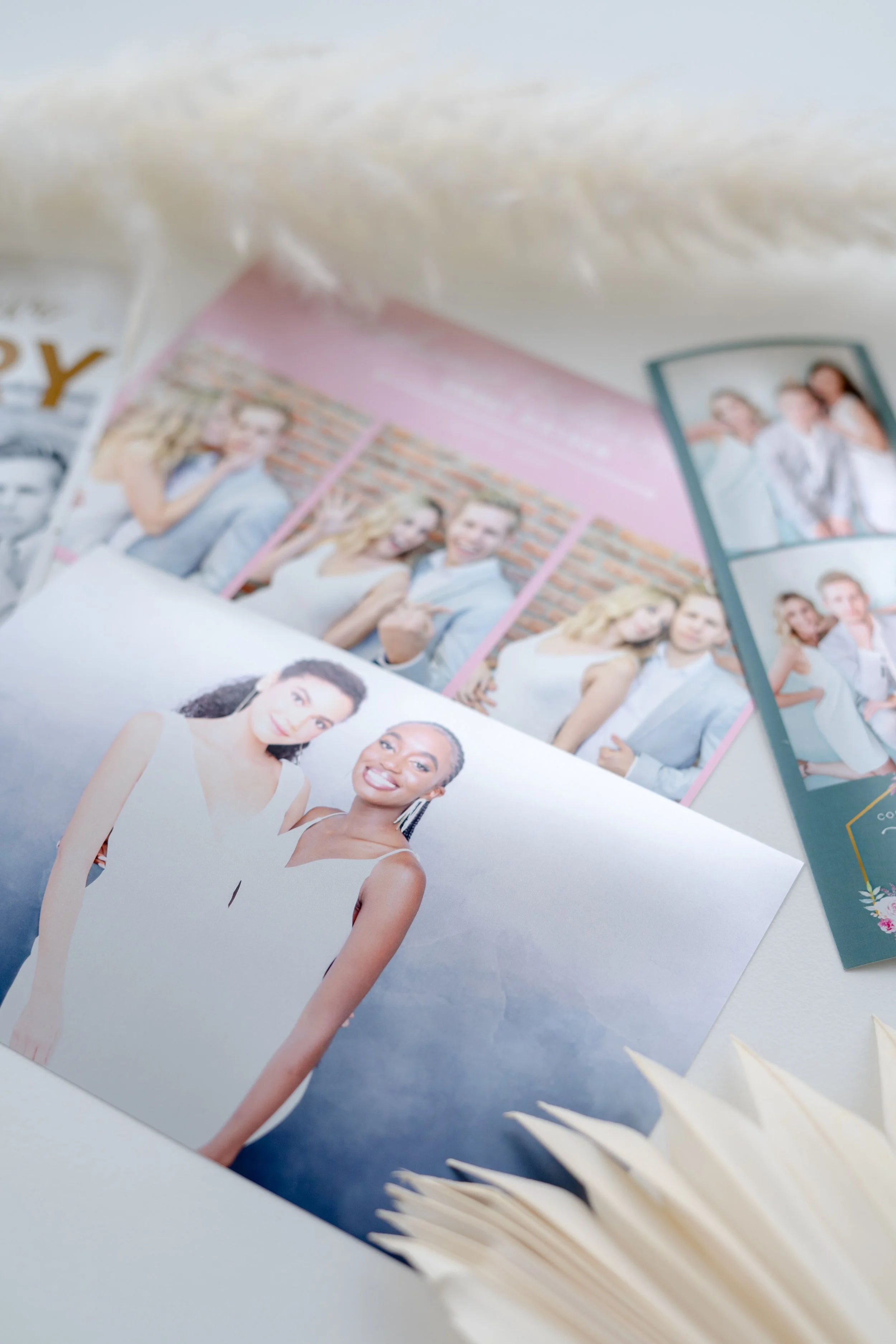 Photographs of diverse women, some smiling, some making hand gestures, and some posing, arranged on a light-colored surface with wooden skewers or toothpicks nearby.