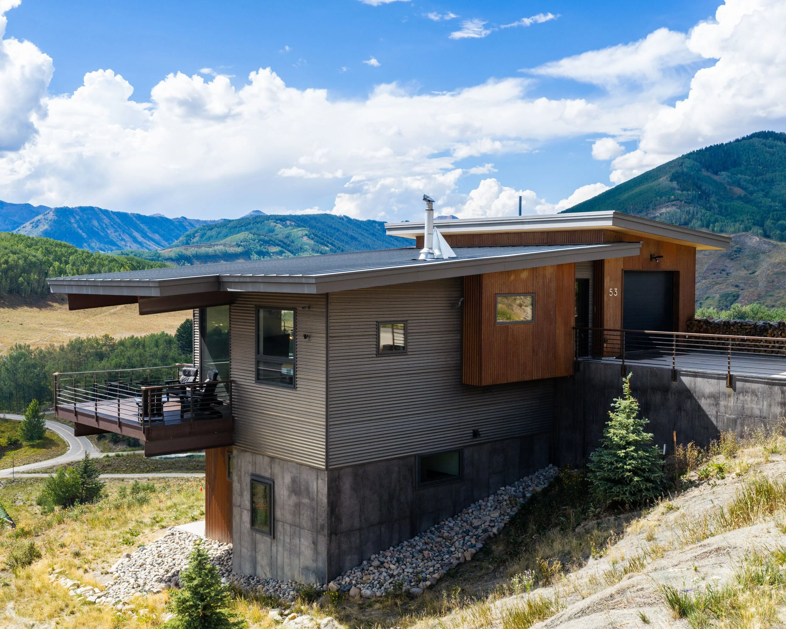 Completed hillside home matching the design rendering, board-formed concrete and wood siding, Crested Butte area