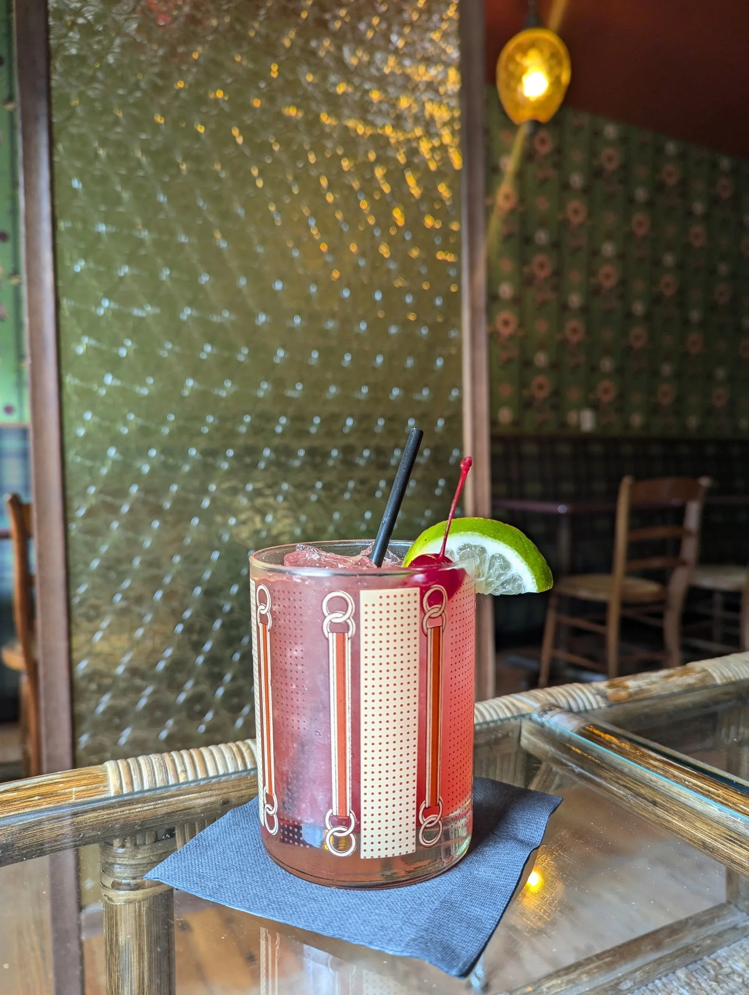 a rocks glass with a cherry and lime showing platypus' cherry limeaid