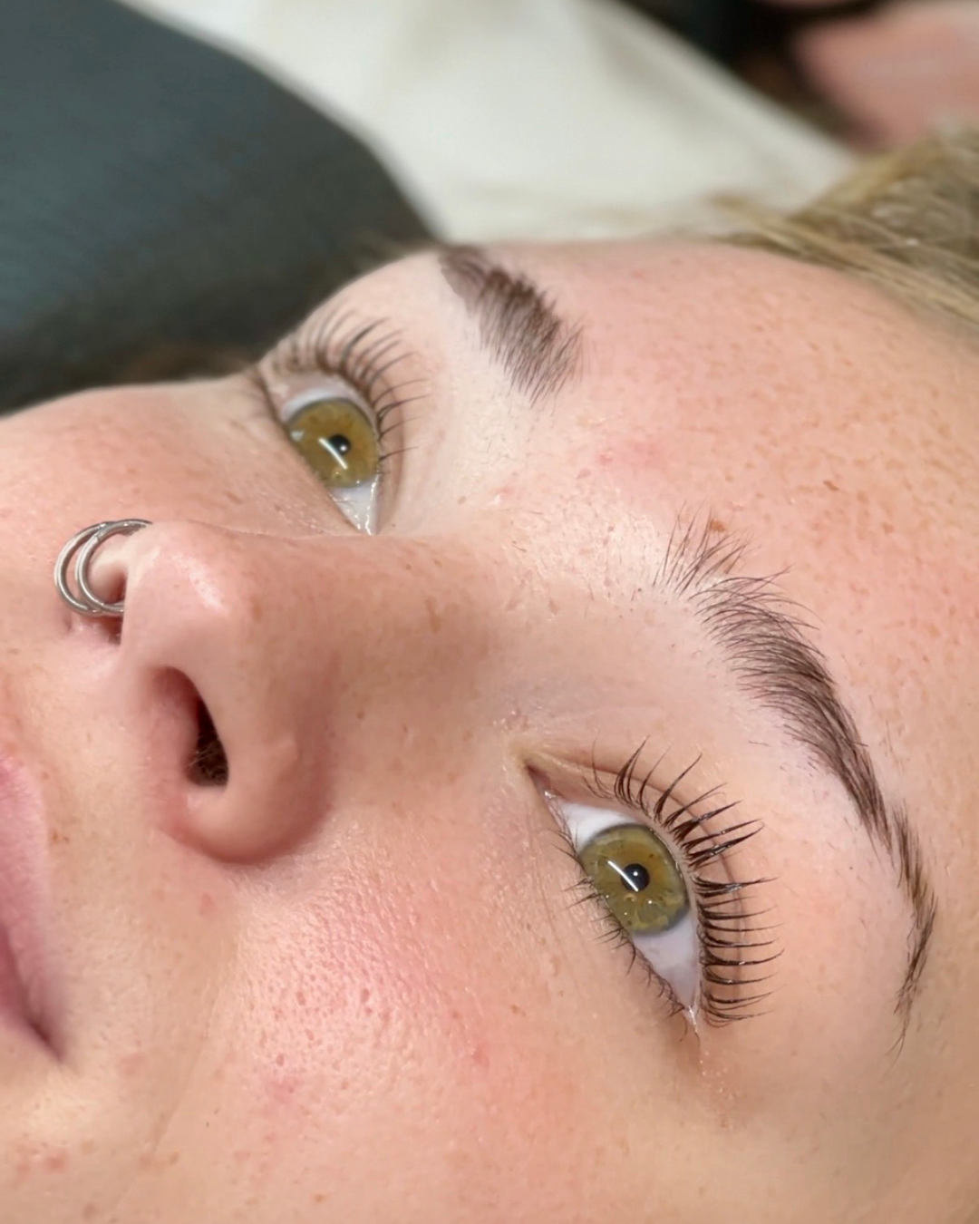 Close-up of a woman's face showing her brows and korean lash lift.