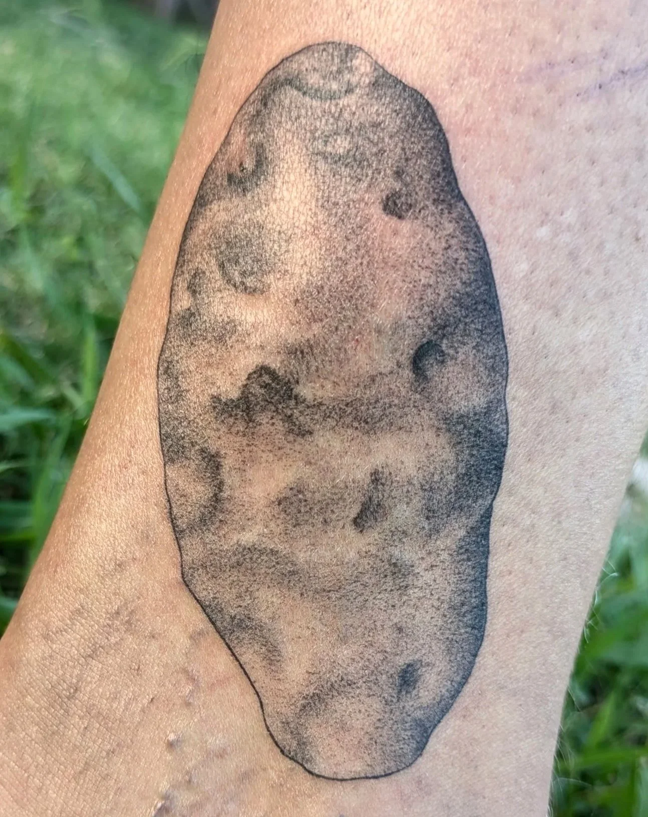Stippled black and gray potato tattoo