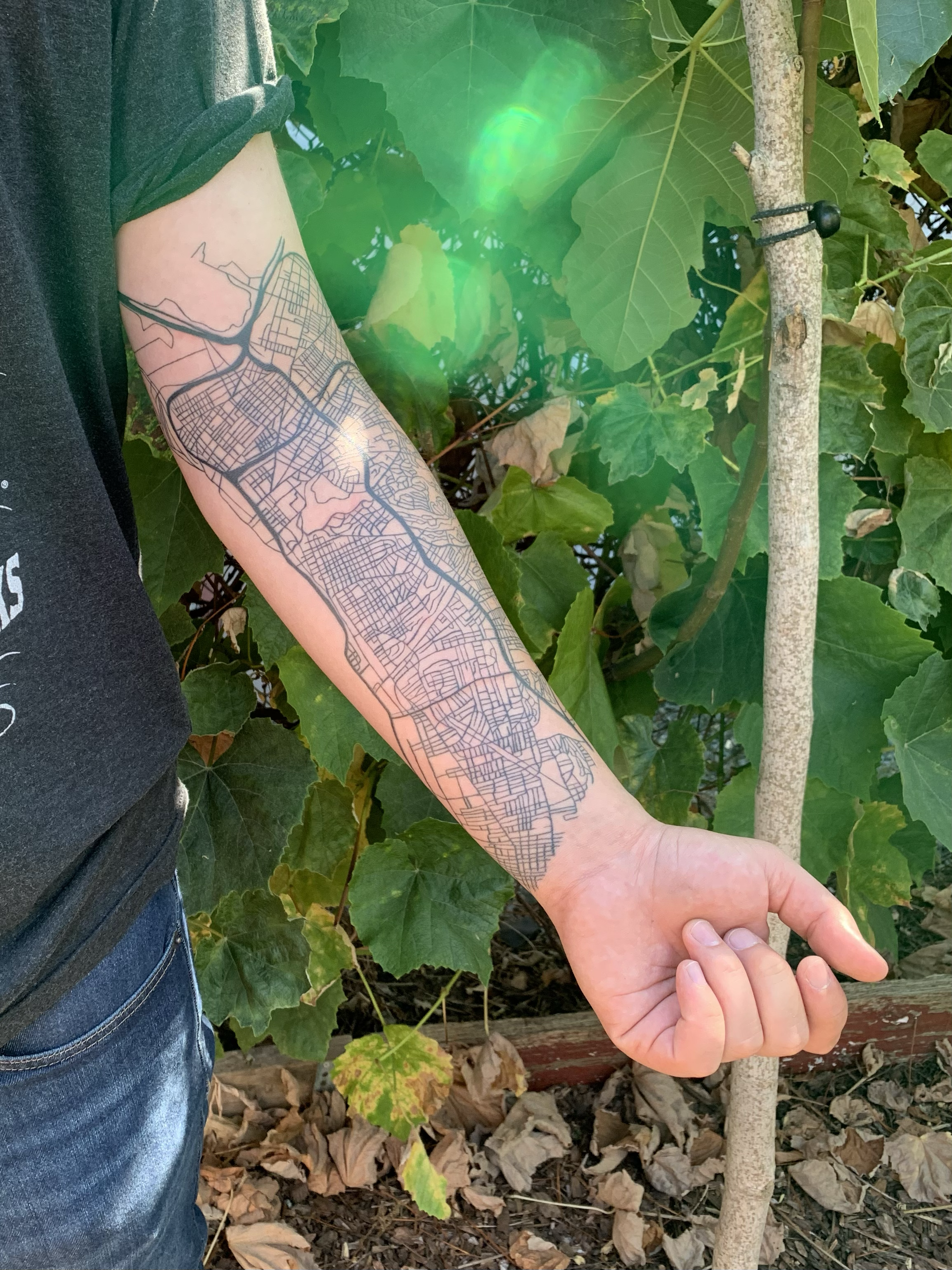 Fine-line sleeve tattoo on the forearm