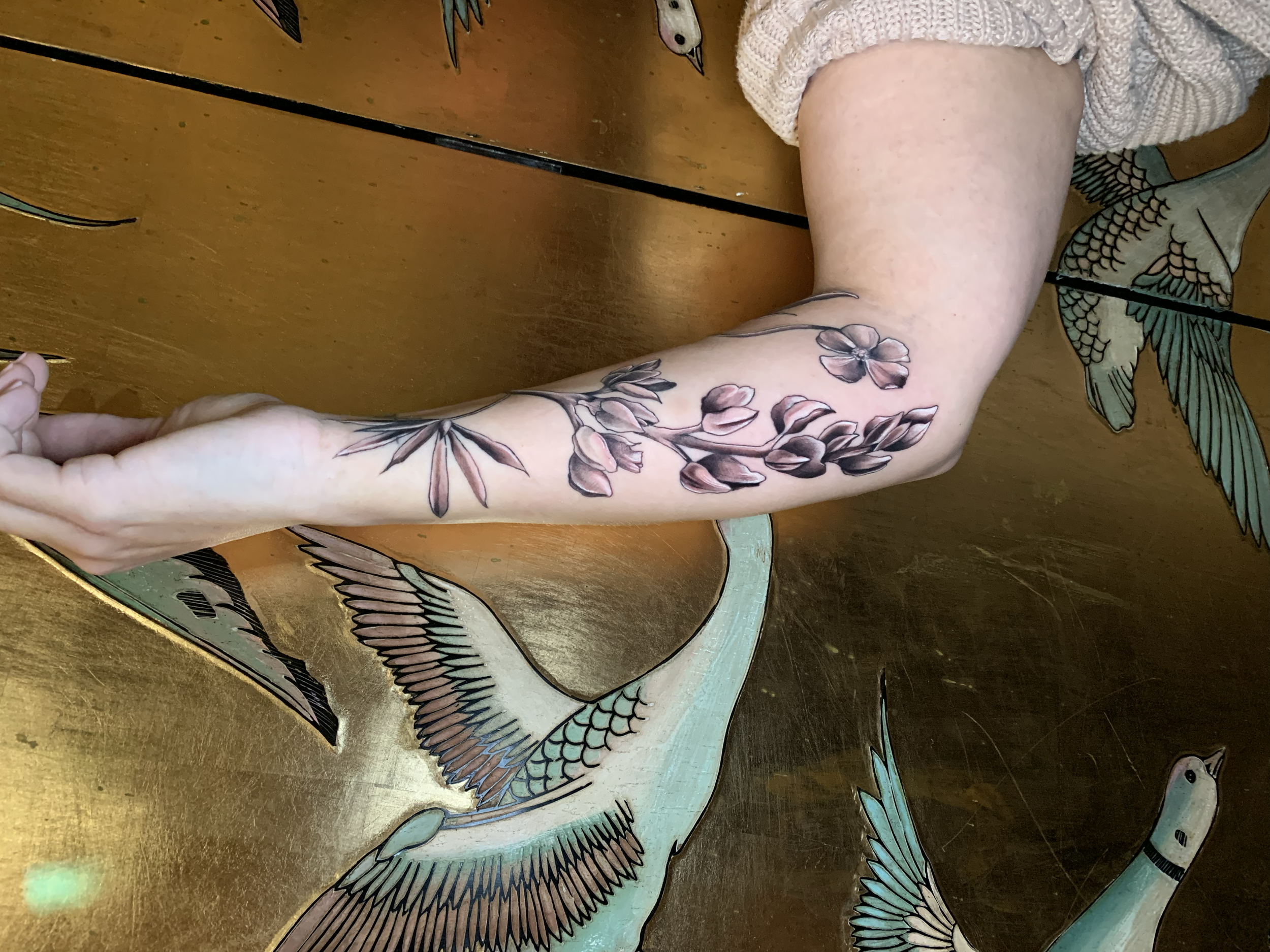 Floral forearm tattoo in fine black linework