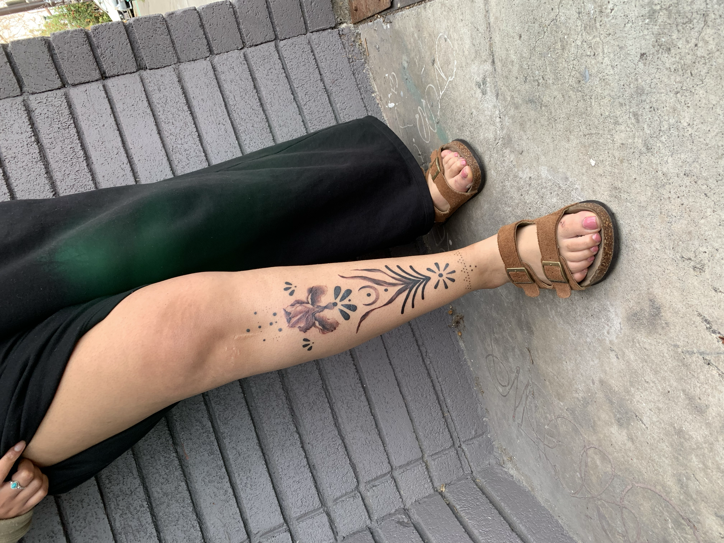 Fine-line botanical tattoo on the lower leg