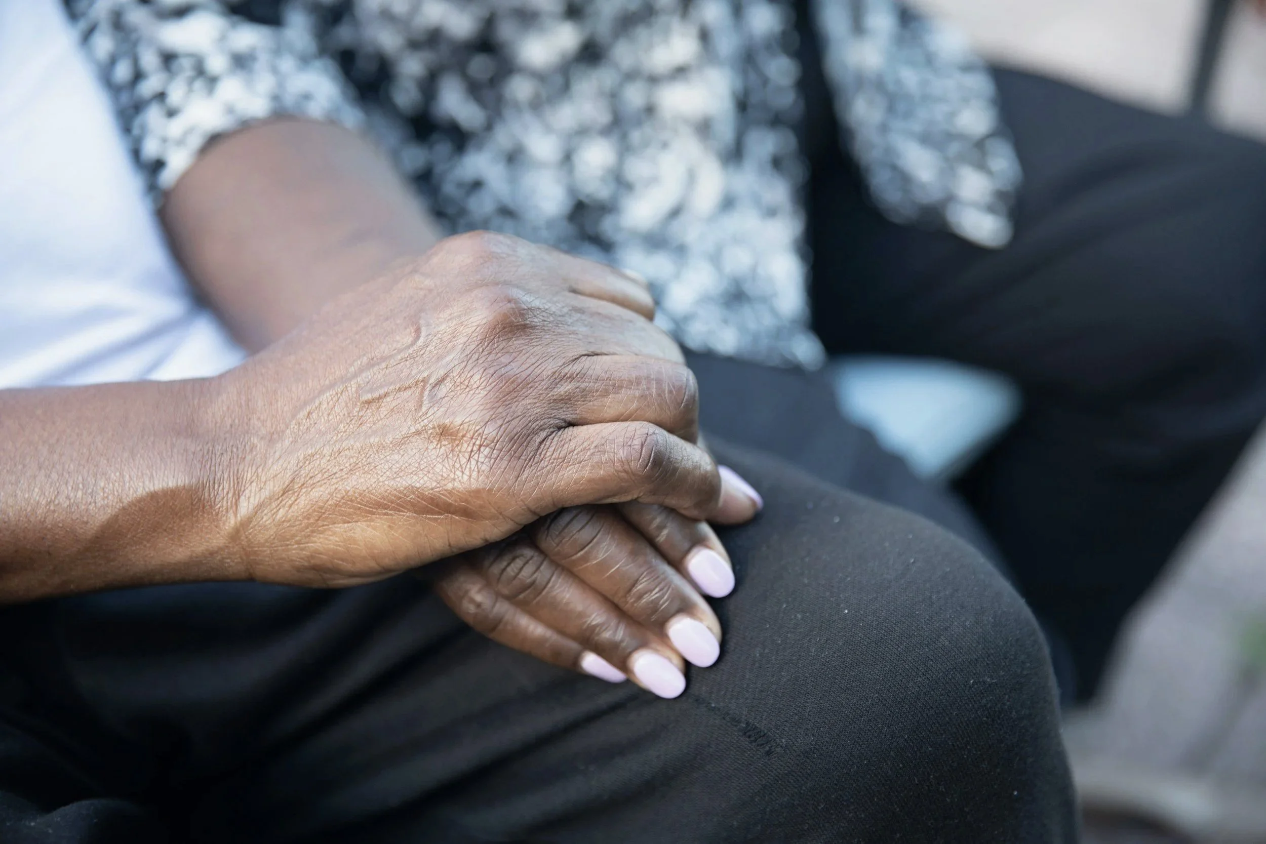 Hands resting together in a supportive gesture.
