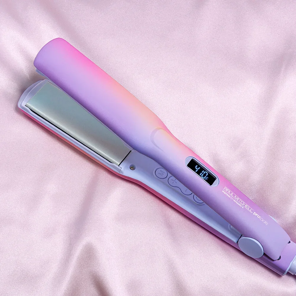 A pastel-colored hair straightener with a digital temperature display printed on a pink satin fabric background.