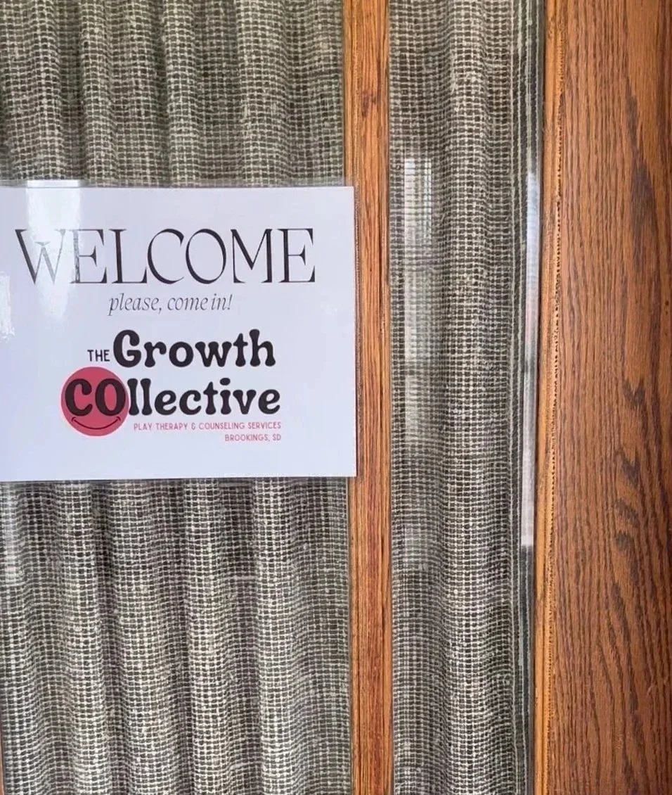 Sign on door welcoming visitors to The Growth CO Collective for play therapy and counseling services in Brookings, South Dakota.