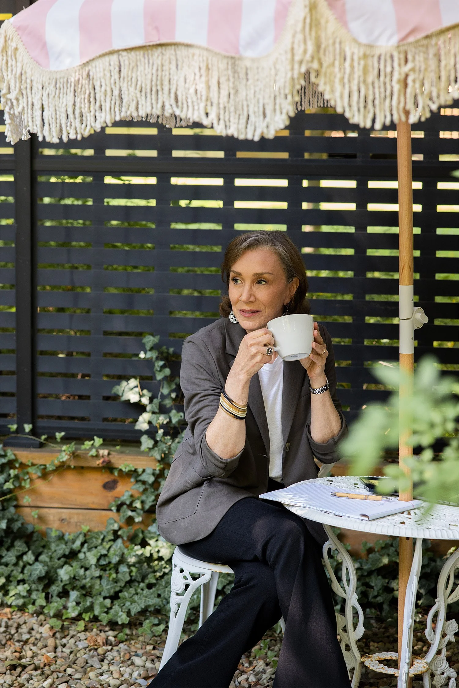 Studio business coach relaxing outdoors with coffee, reflecting on business strategy and planning.