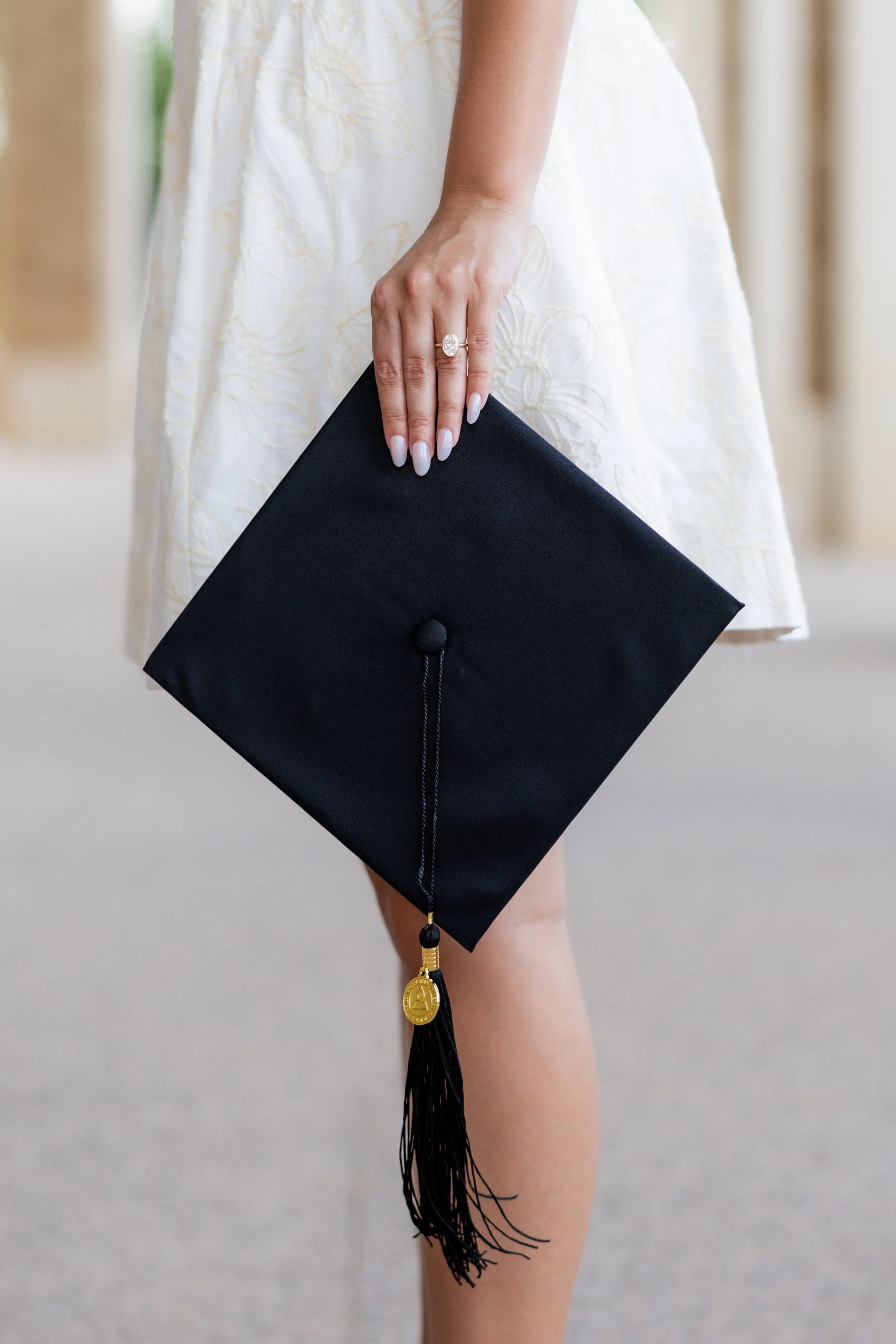 Close-up of a college graduate holding her graduation cap during a graduation portrait session