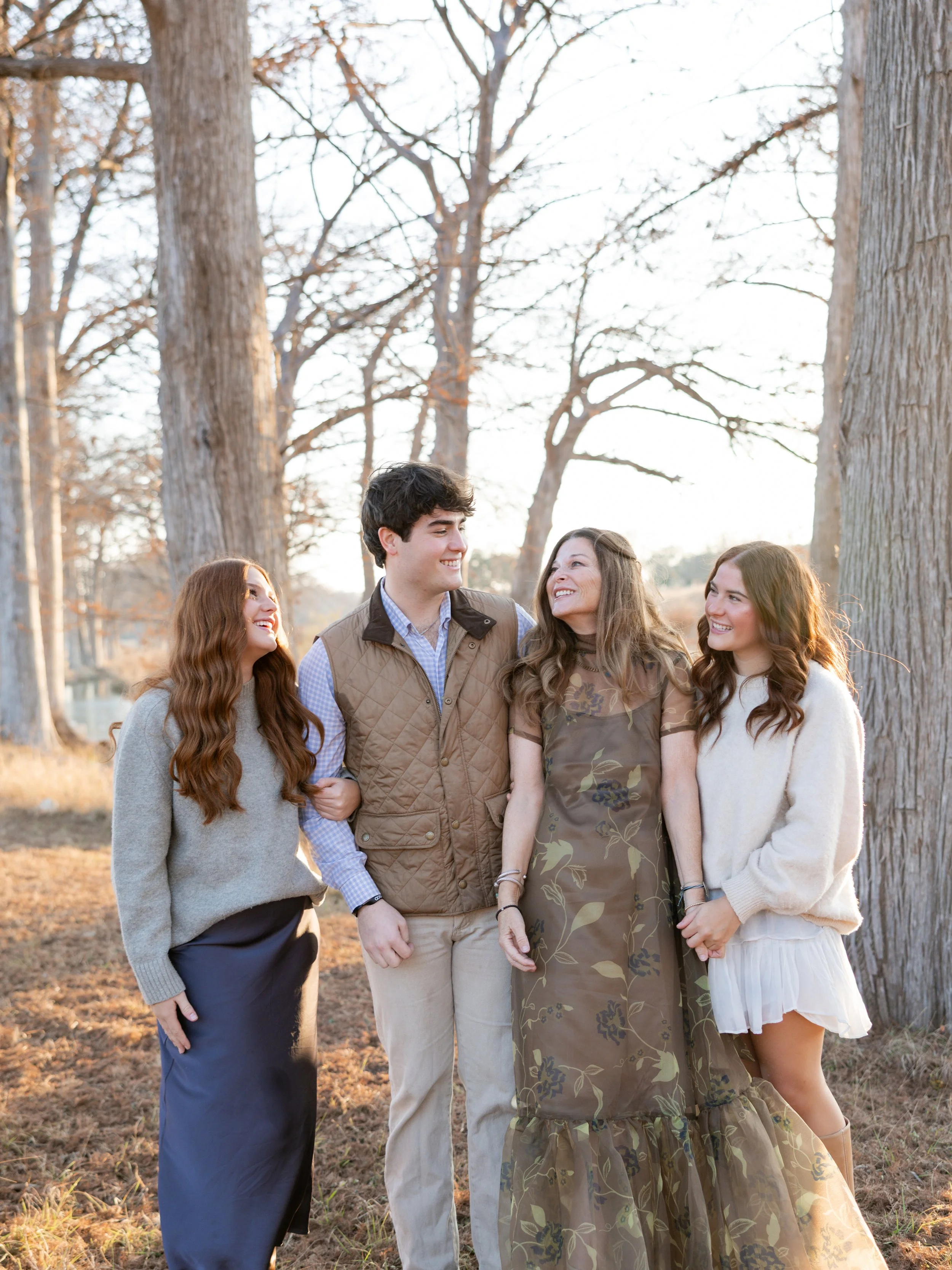 Family of four smiling together during an outdoor family photography session.