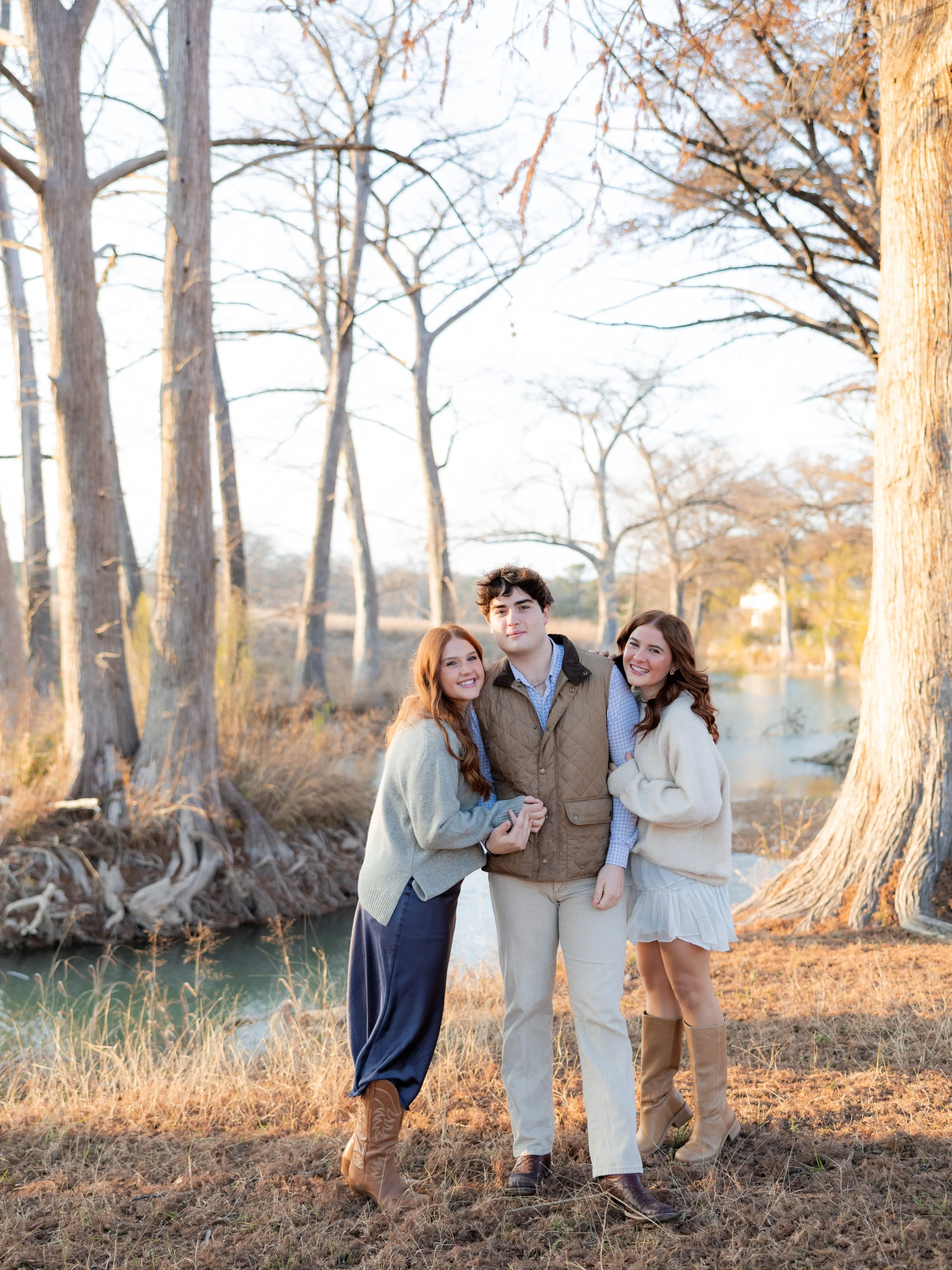 Family of four posing together outdoors during a group family portrait photography session.